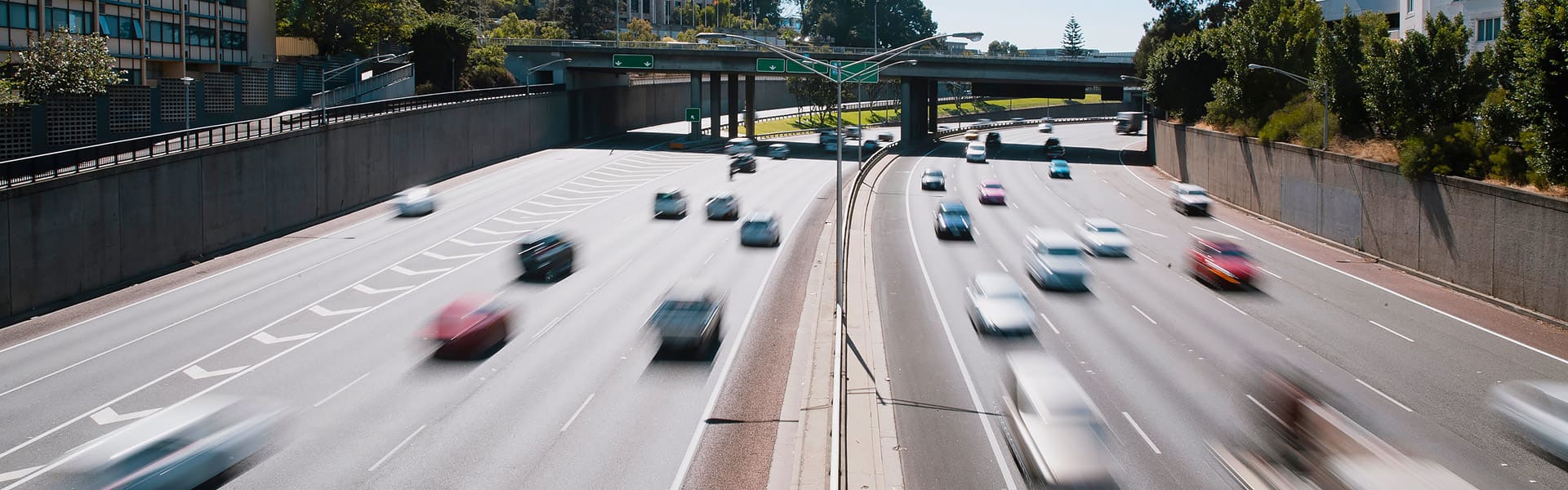 Cars driving under freeway bridge