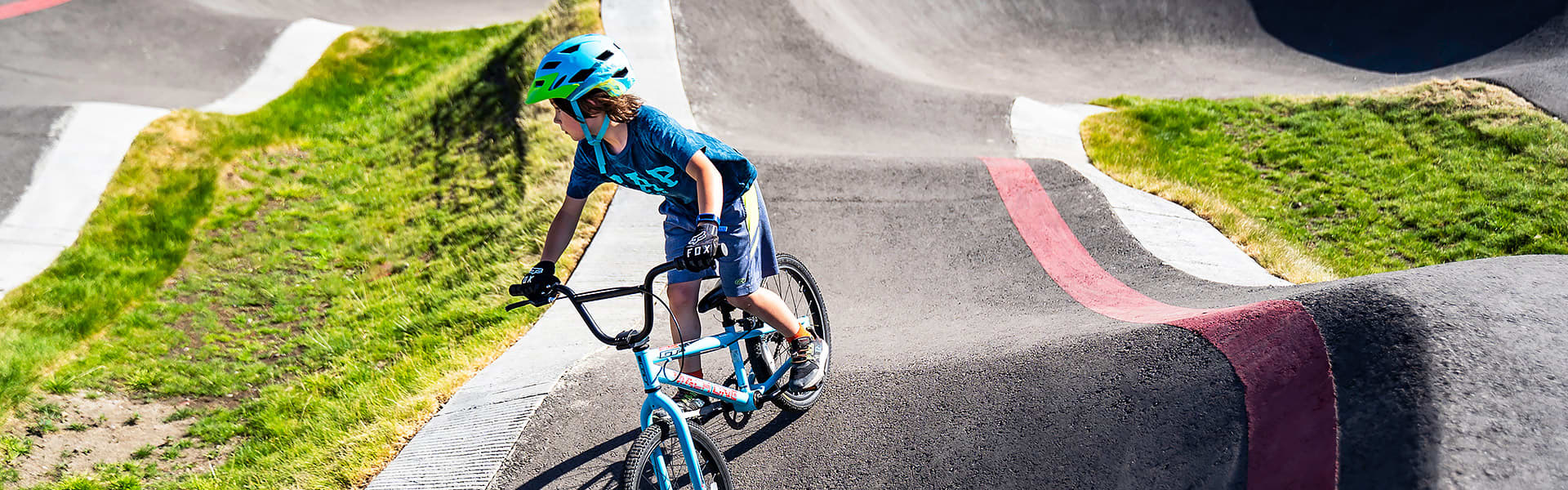 A small child riding a bike around a BMX bike track