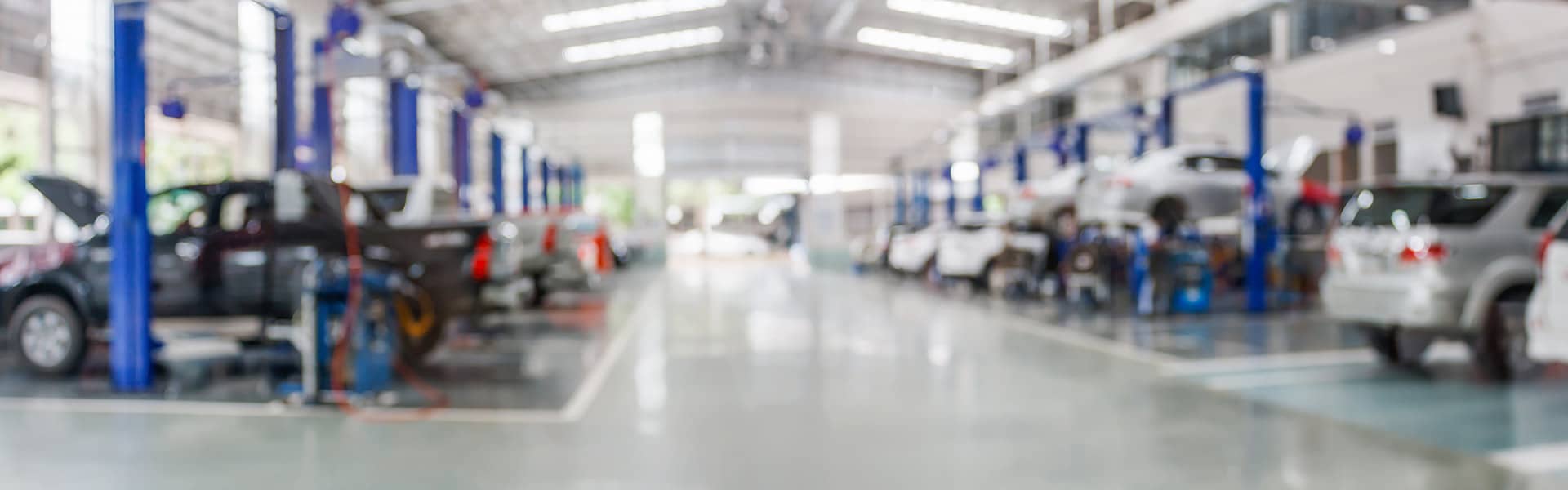 Cars being serviced in a large workshop