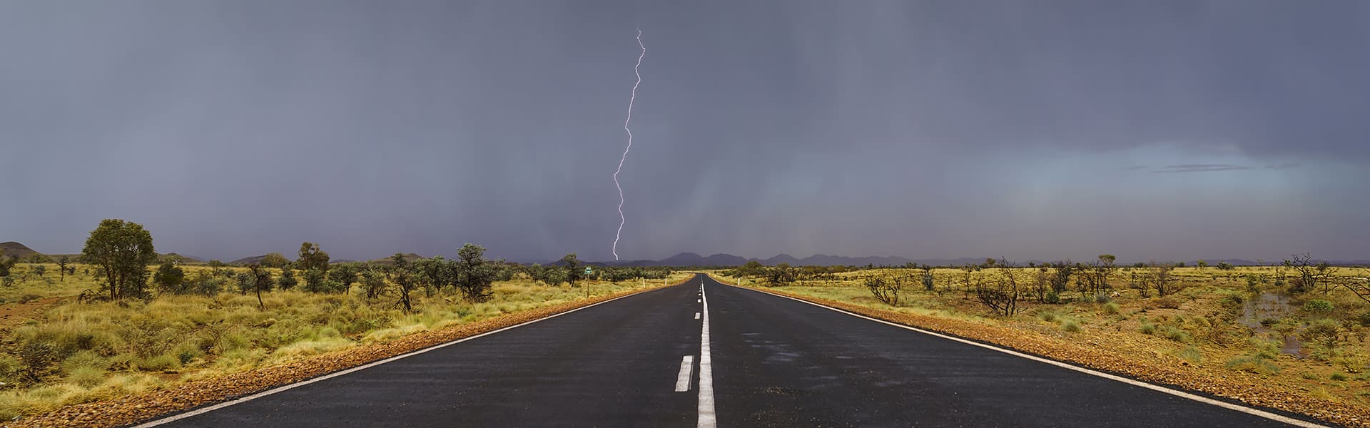 A lightning strike over a remote country road during a storm