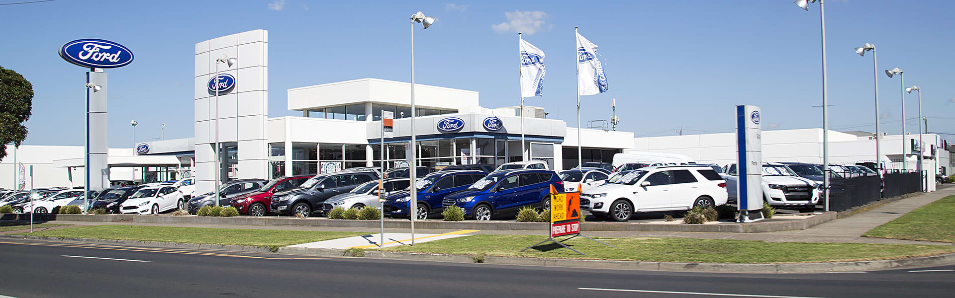 A Ford car dealership seen from the roadside