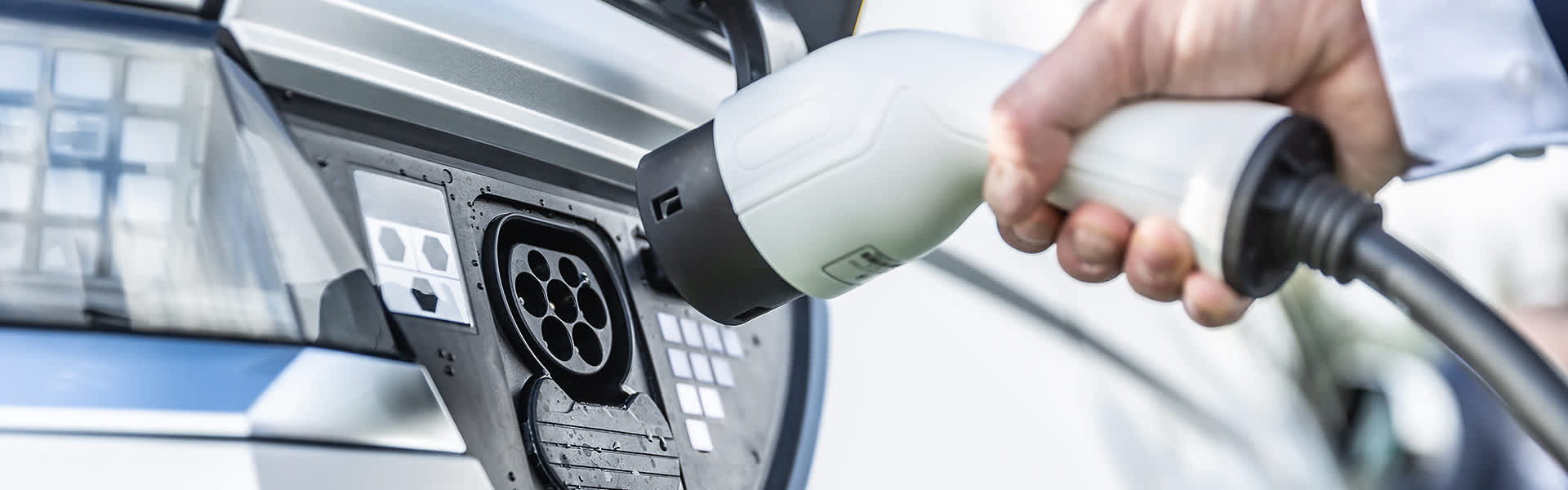 A close up of someone charging an electric car