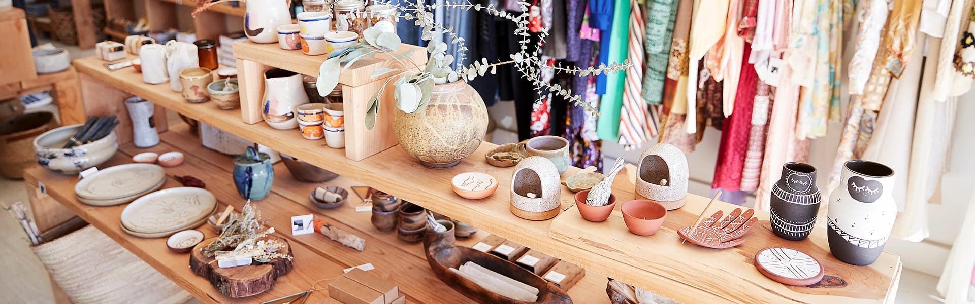 The interior of a gift store showing shelves and racks of homewares and clothing
