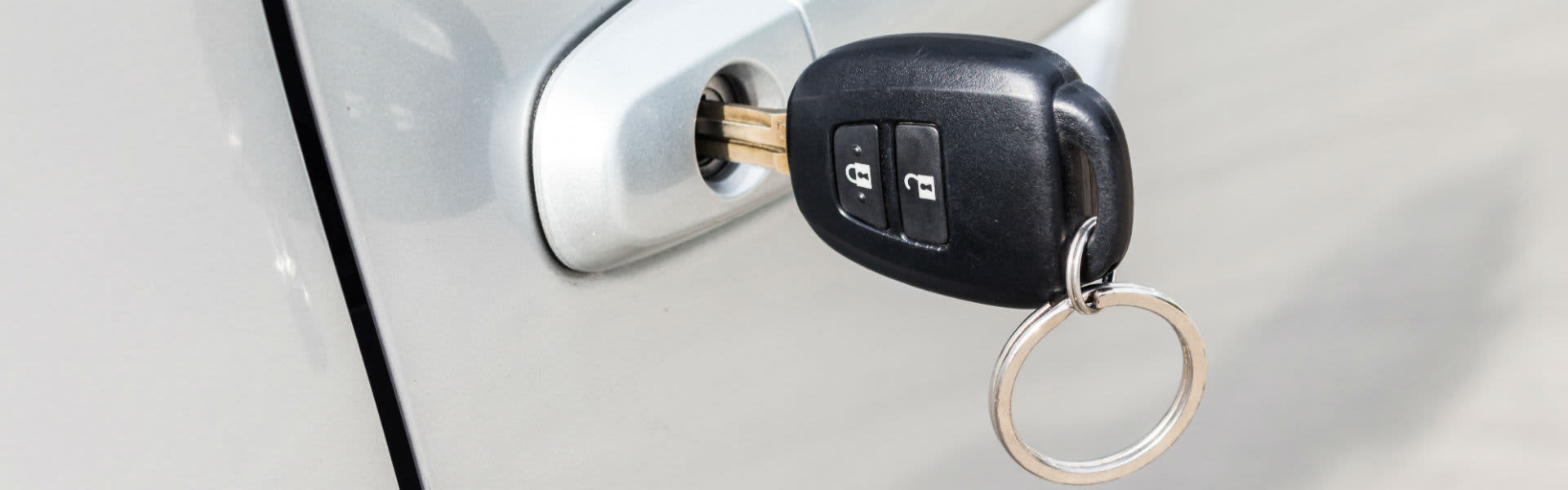Car keys in the door handle of a white car