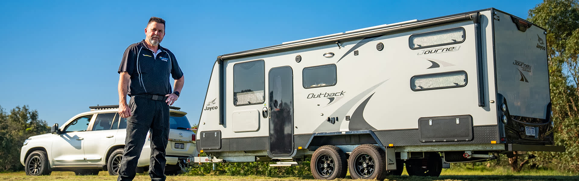 Instructor standing in front of caravan and car