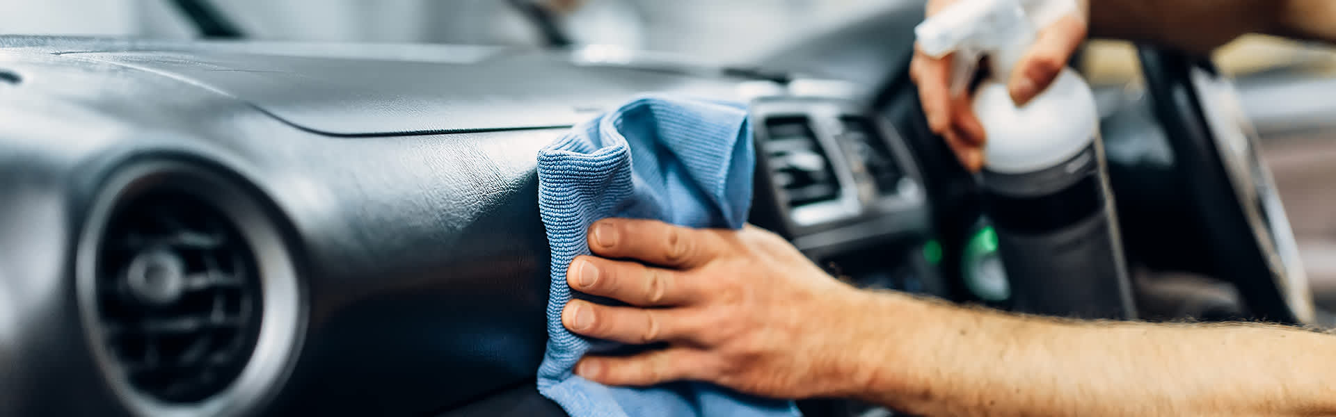 A close-up of someone polishing a dashboard