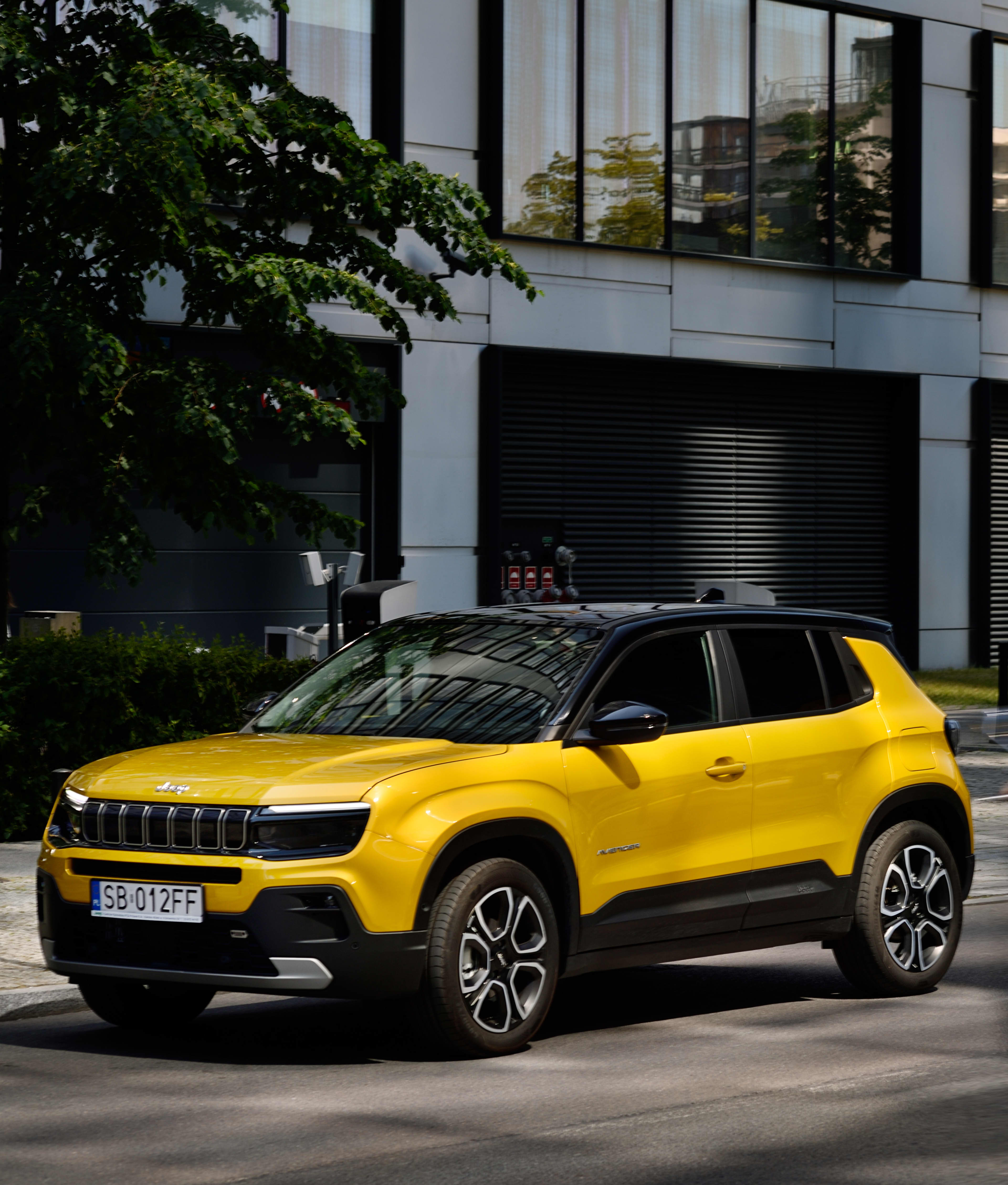 A yellow Jeep parked on a street