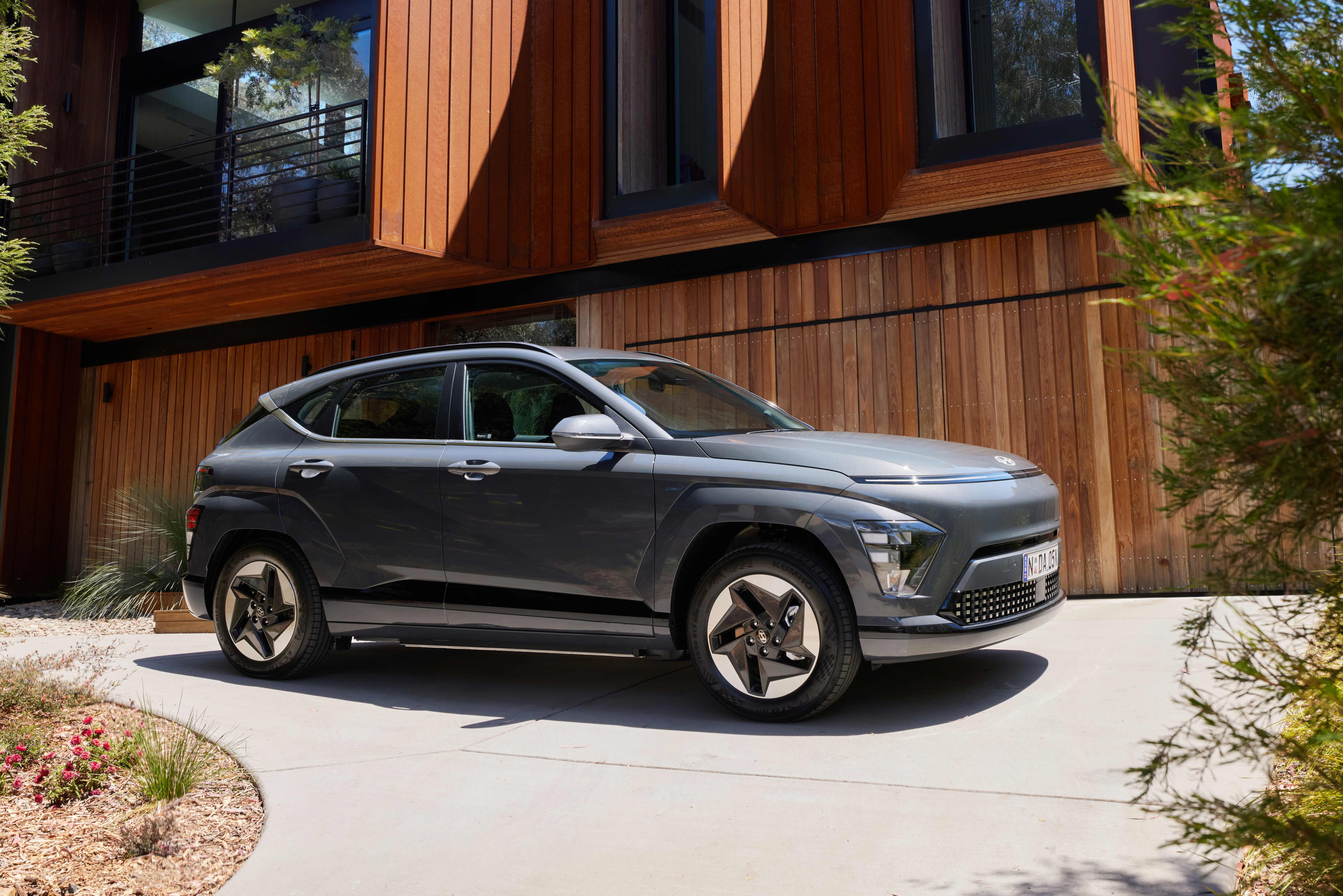 A grey Hyundai Kona Electric parked outside a home