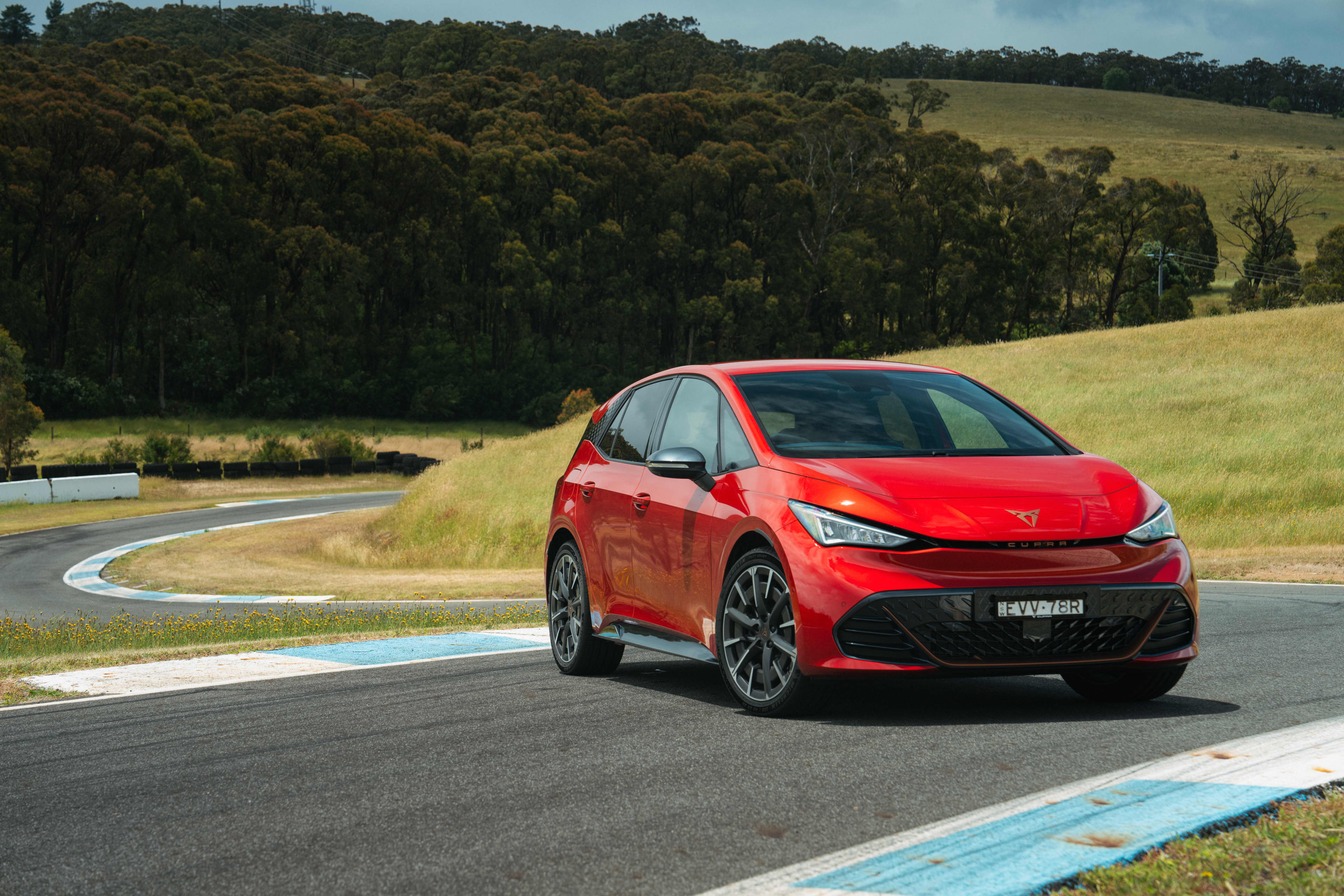A red Cupra Born parked on a circuit