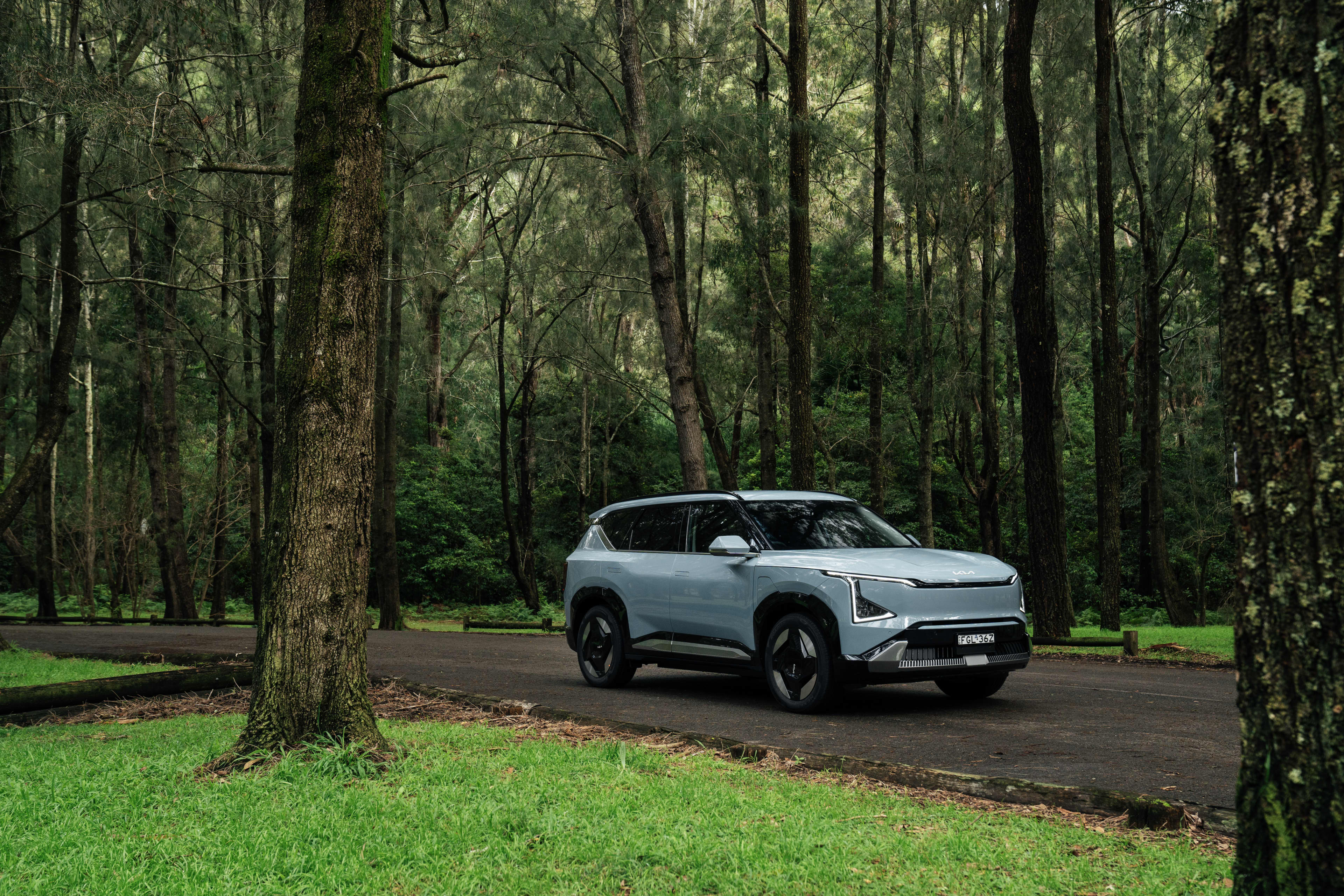 A 2025 Kia EV5 parked in a woodland area