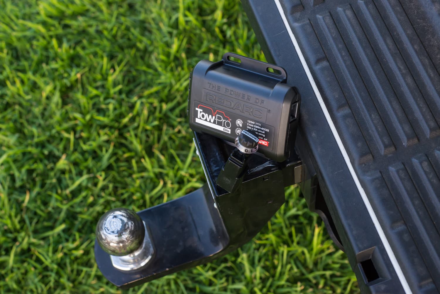 A Tow ProElite caravan brake controller device resting on a tow bar