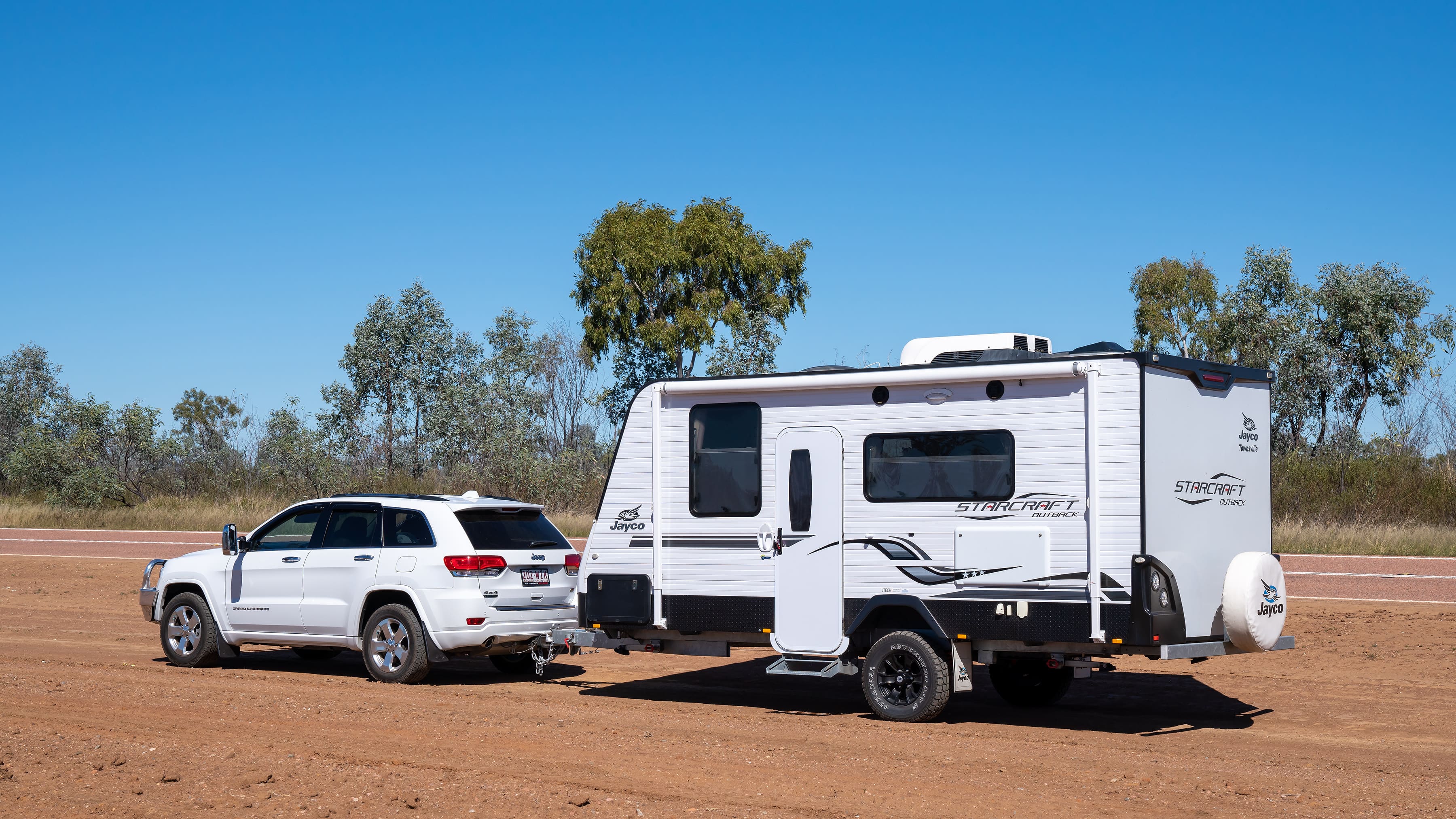 A car with a caravan pulled over at a remote rest stop