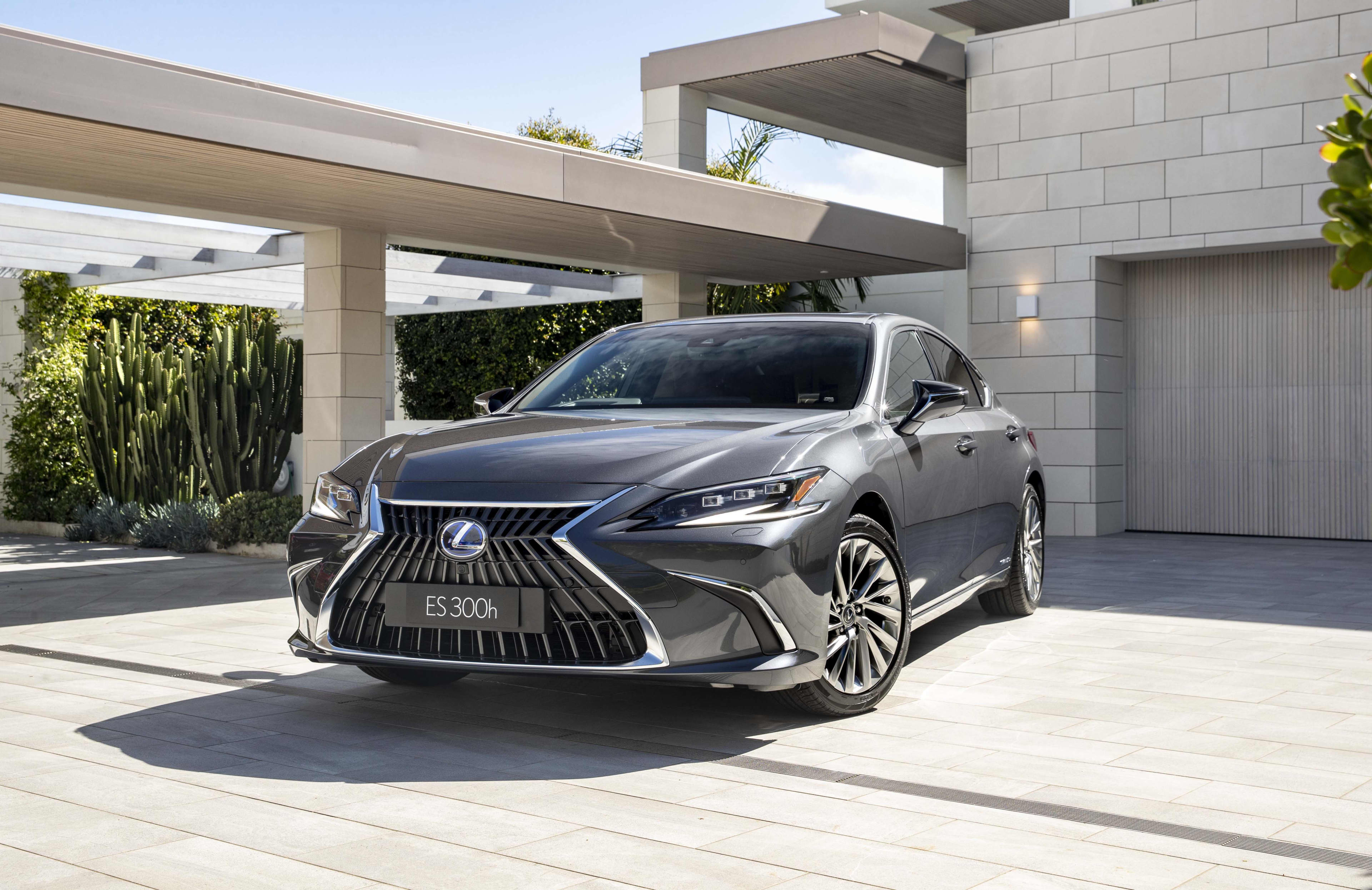 A dark grey Lexus ES 300 parked outside a modern home