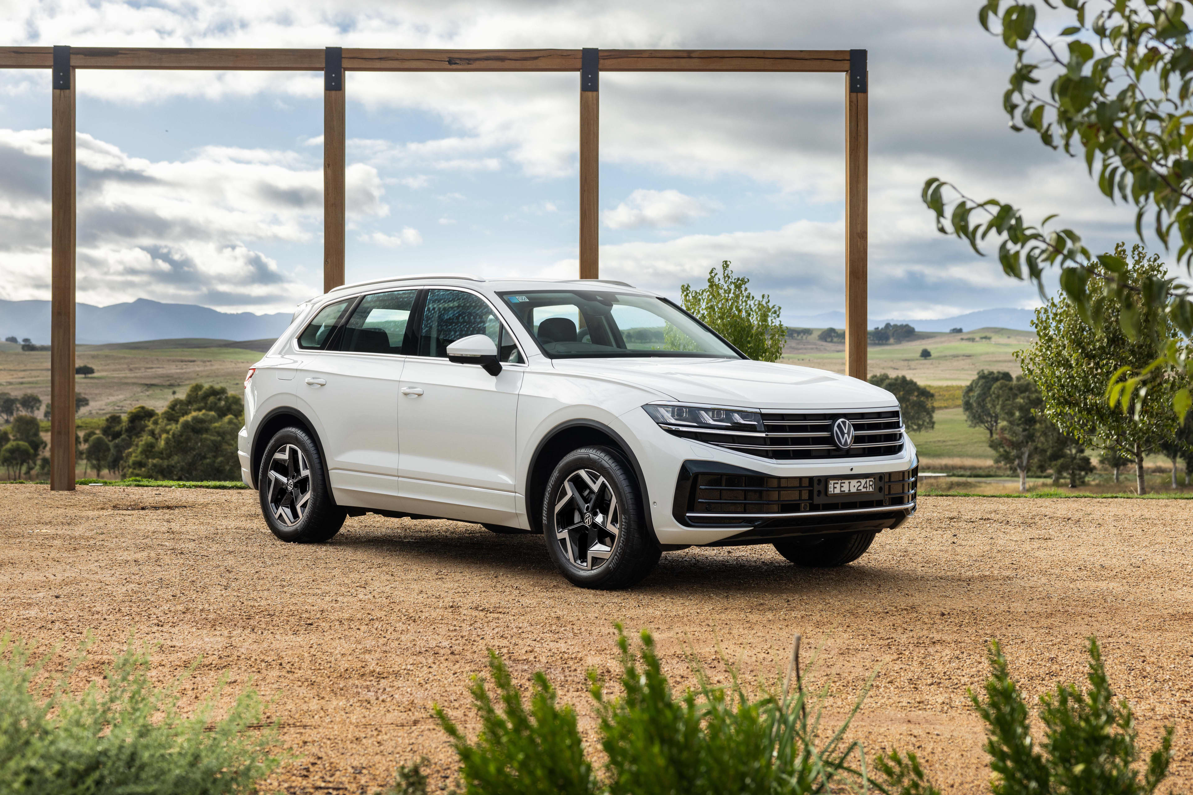 A white Volkswagen Touareg parked in rural setting