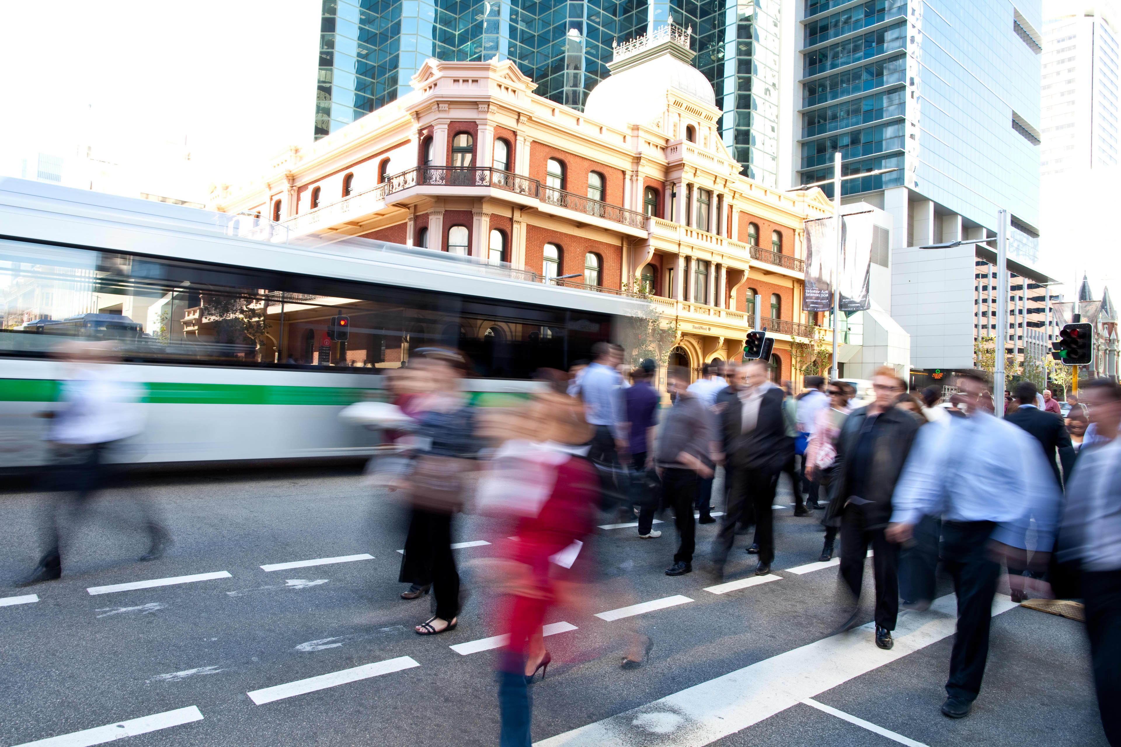 People crossing a busy road on St Georges Terrace in Perth, WA