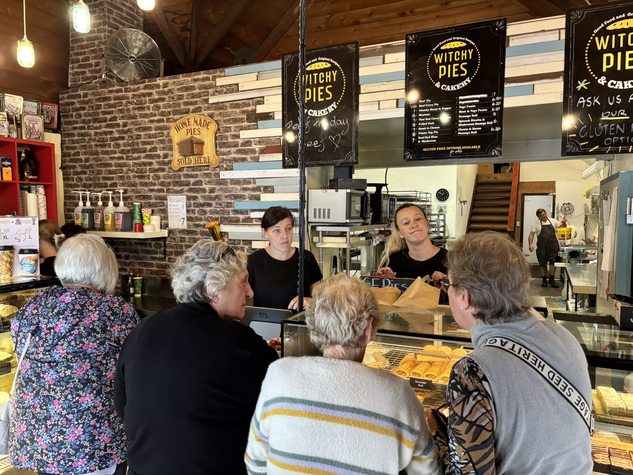 Customers being served at the counter inside Witchy Pies