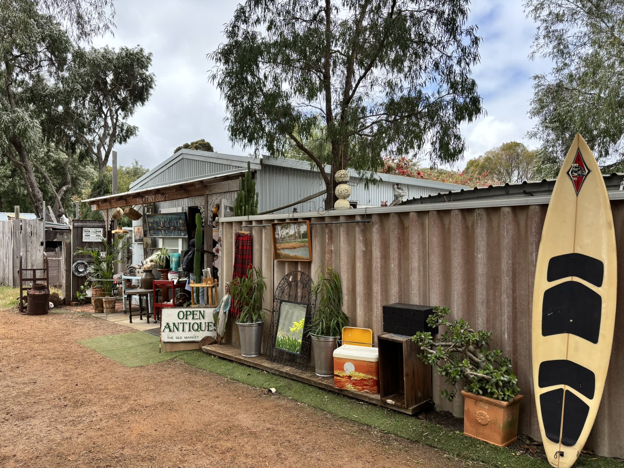 The exterior of the Tiny Store showing items lined up against a fence