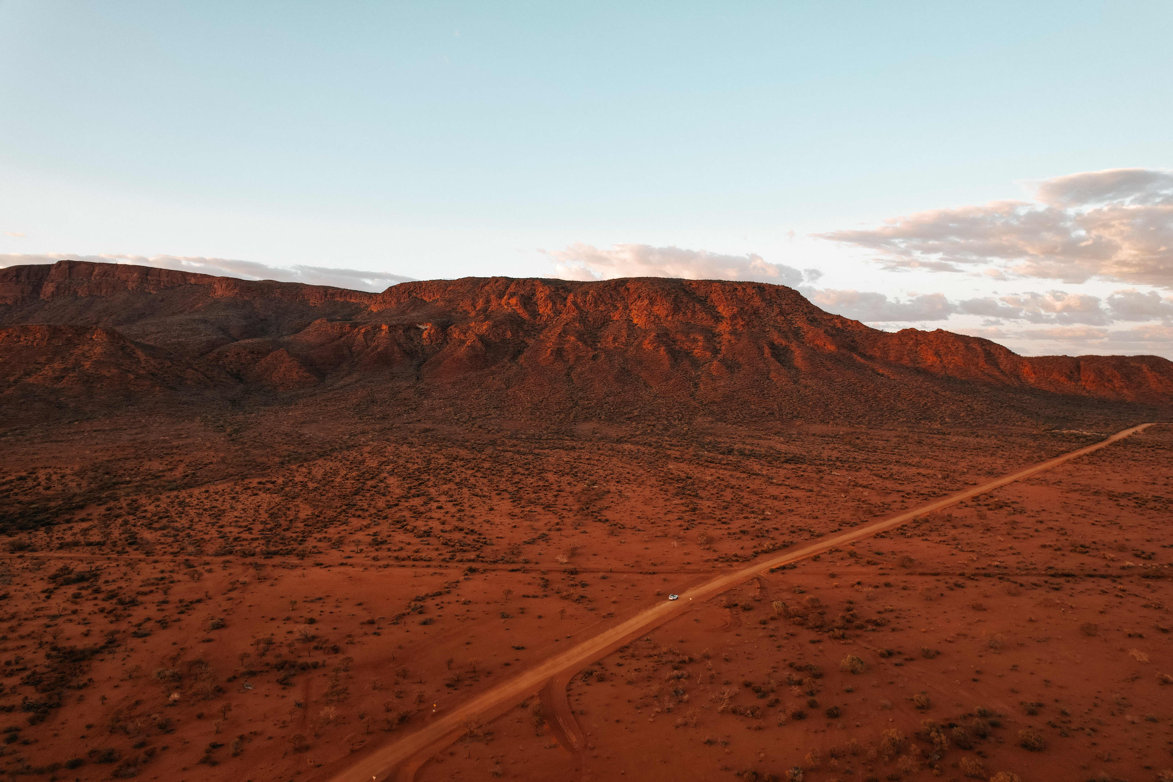 A red dirt road with Mt Augustus in the background