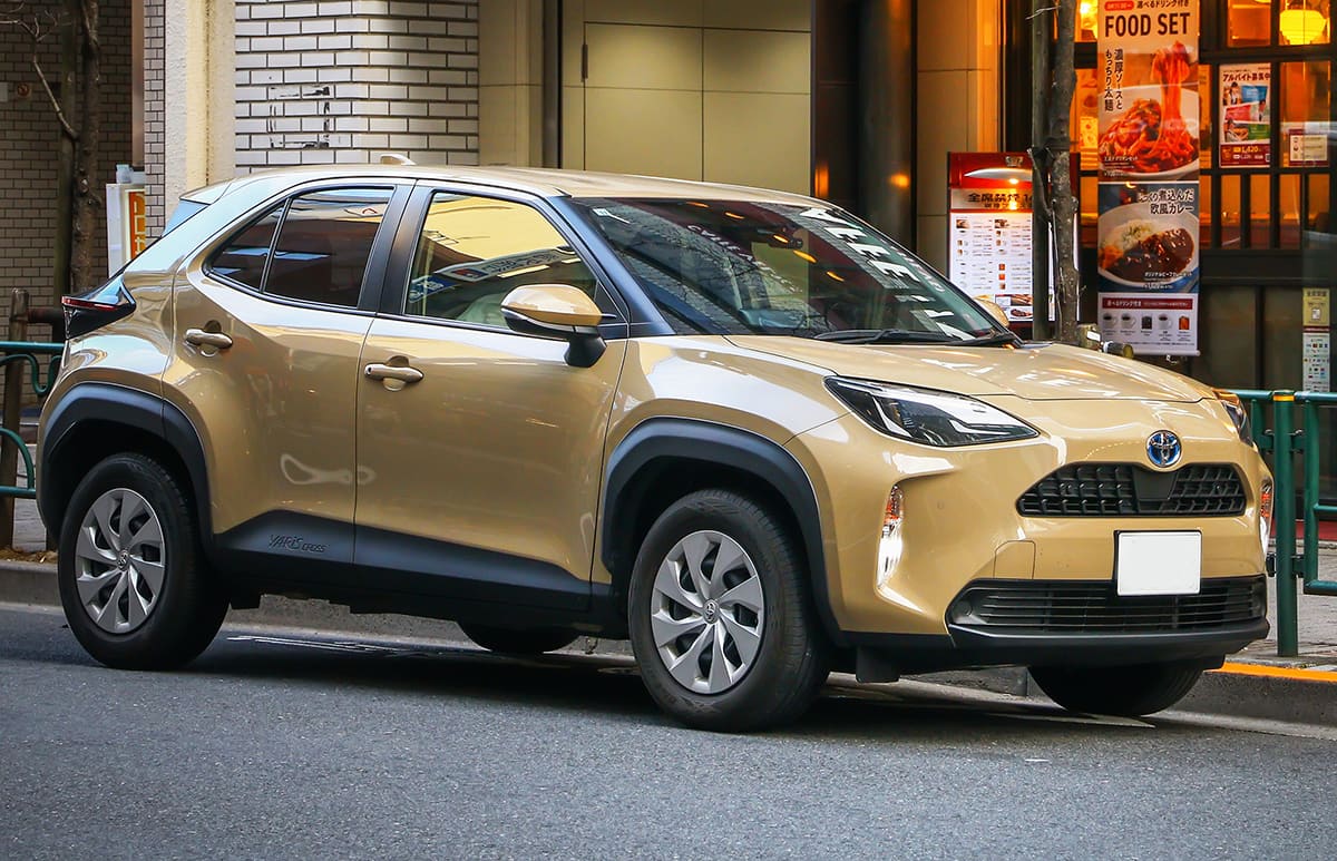 A light brown Toyota Yaris Cross parked outside a restaurant