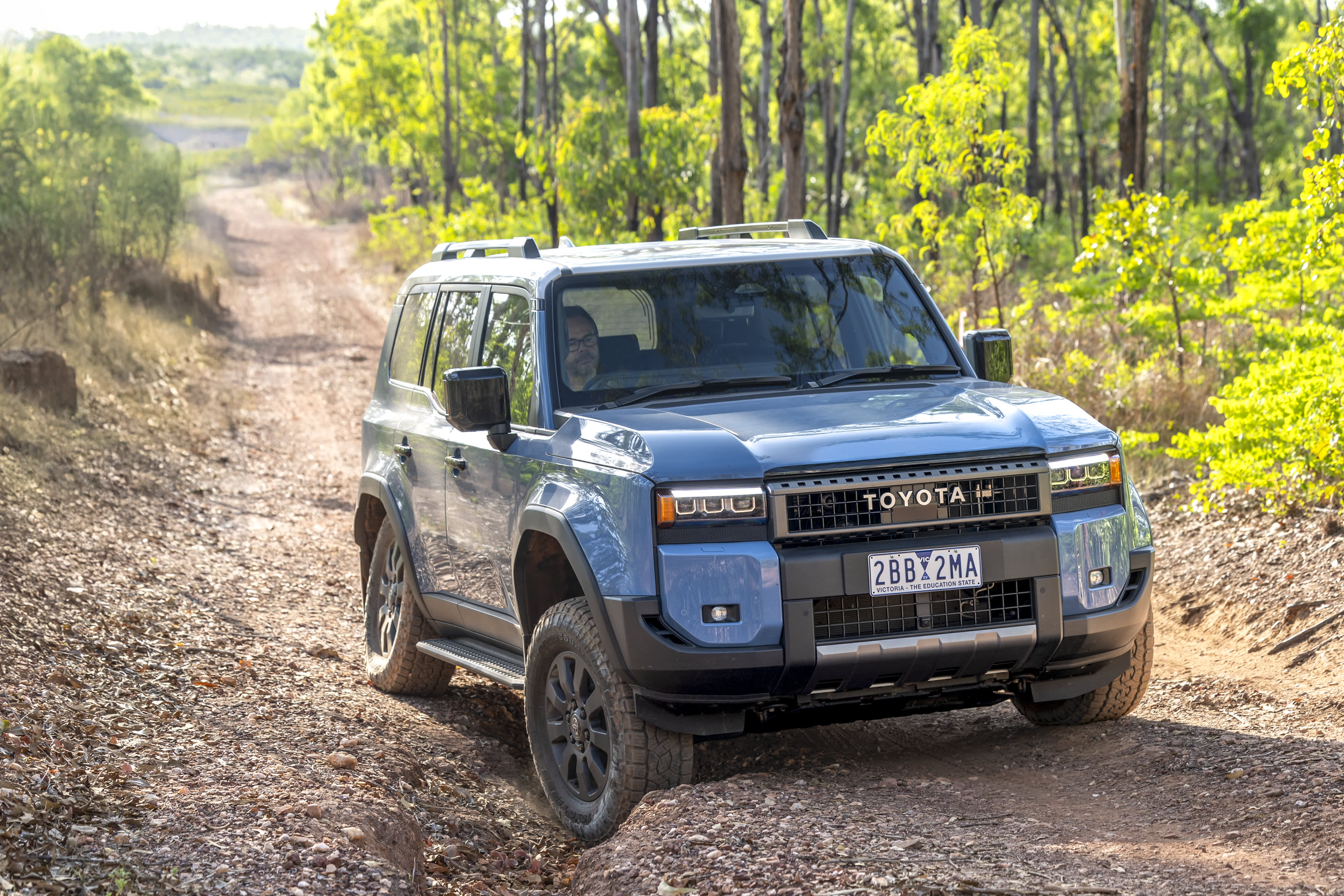 A blue Toyota Prado on a bush track