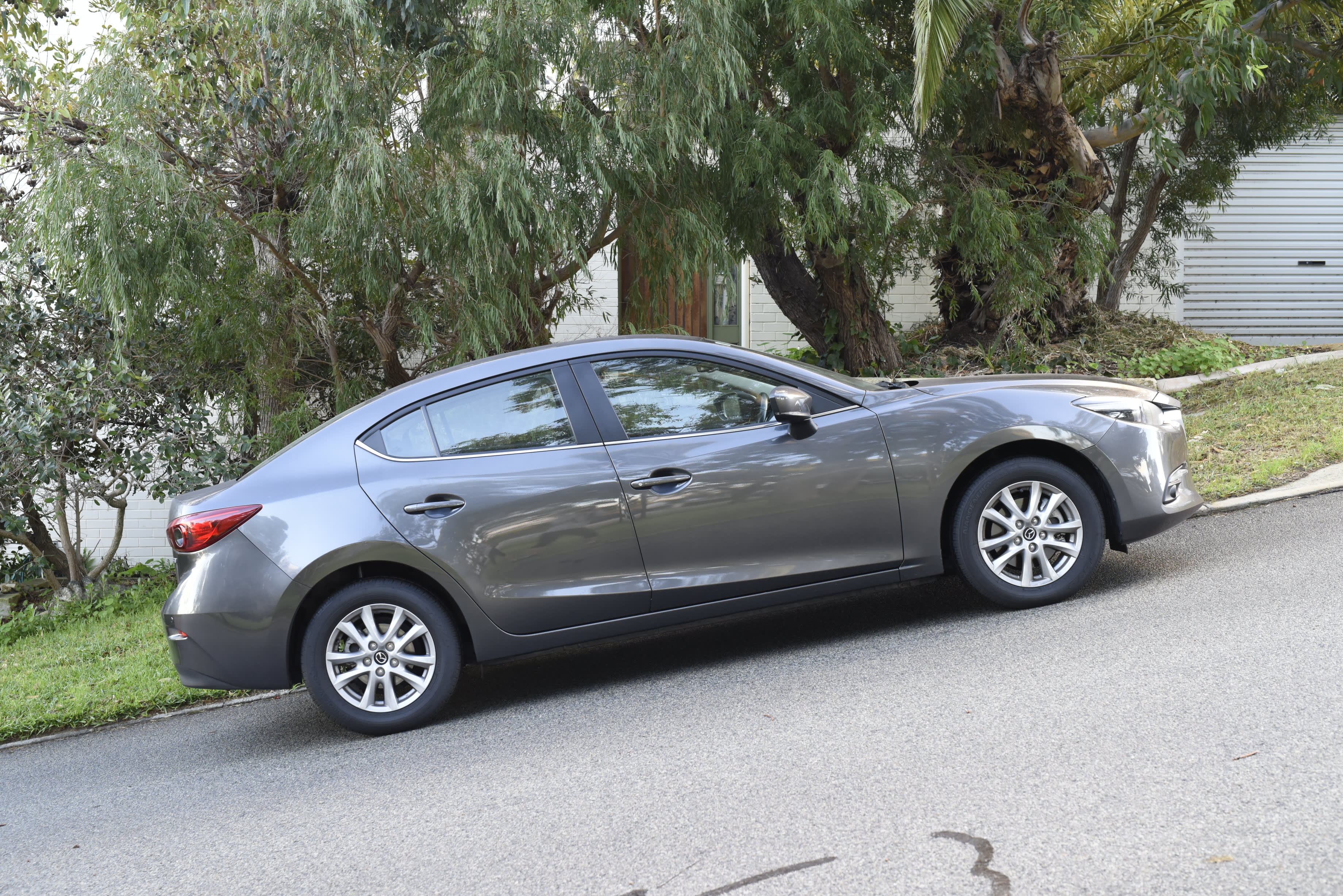 A grey car parked on a steep suburban street