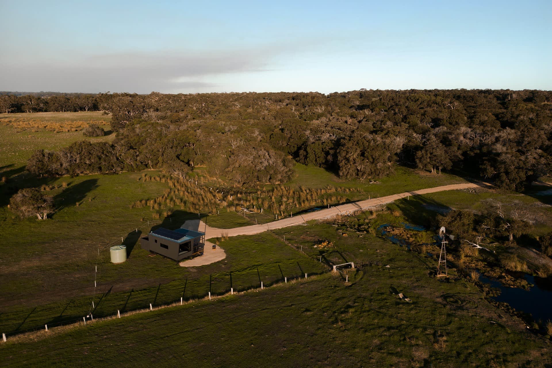 A drone shot of a Heyscape Yallingup cabin showing the cabin situated by a rural paddock