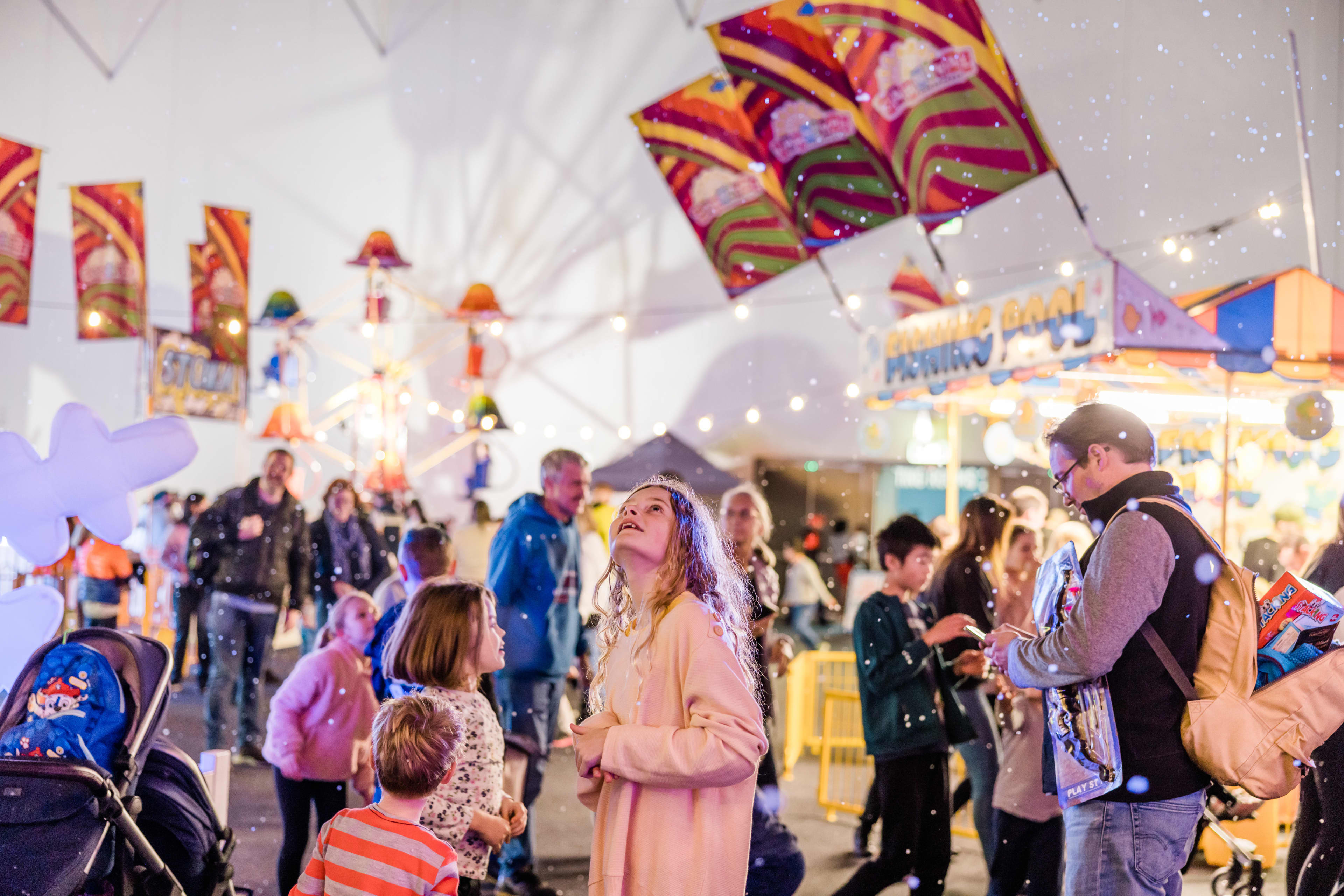 Crowd of people at an indoor winter festival.