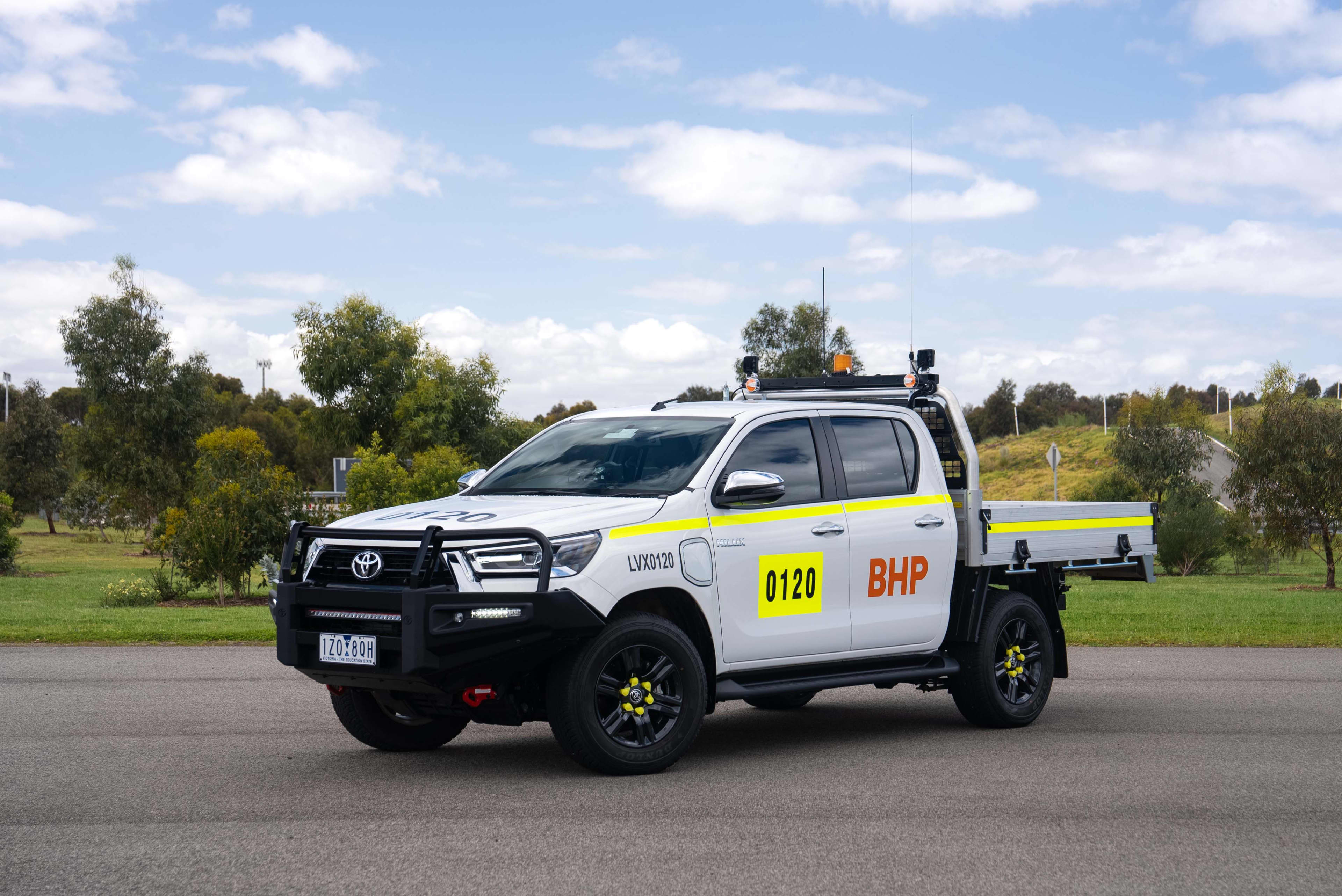 A white Toyota ute with a BHP logo on the side in a car park