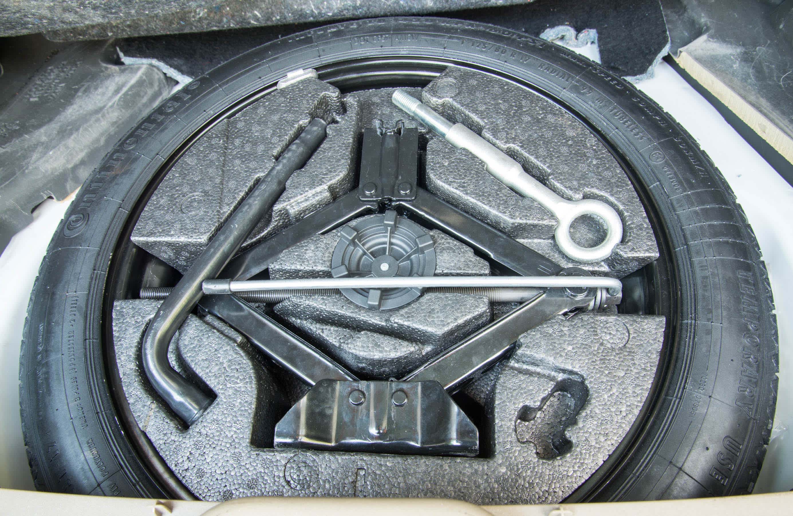 A full-size spare tyre stowed away in a car boot