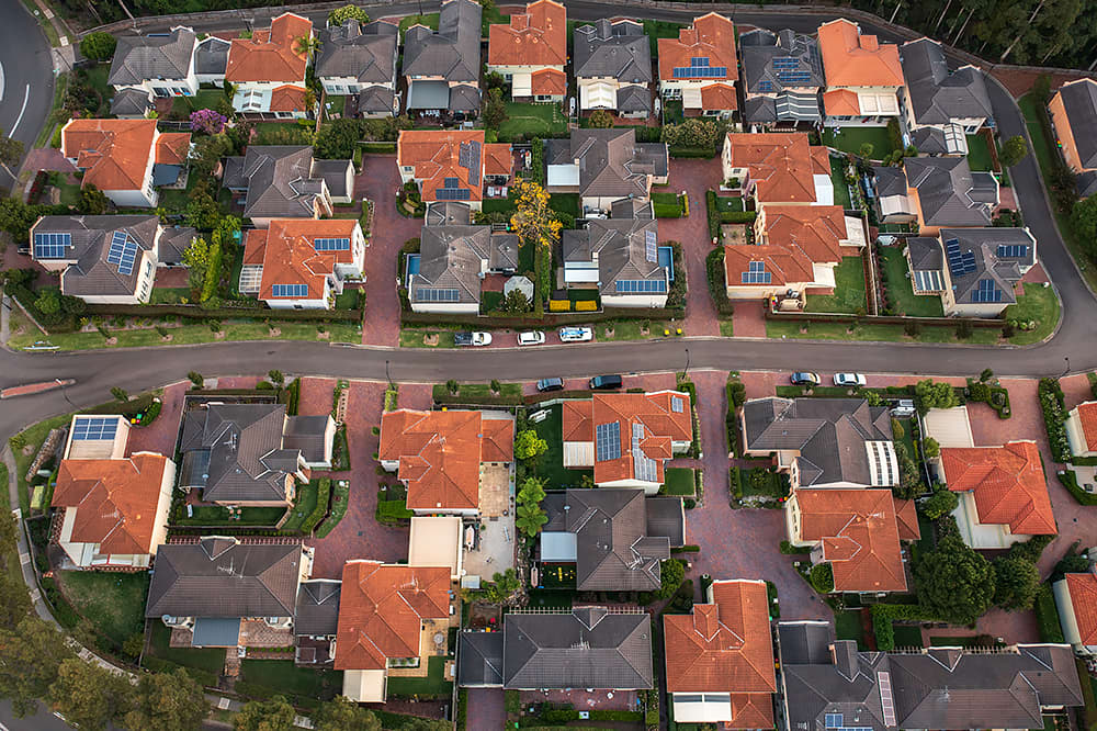 An aerial view of household roofs with solar PV systems
