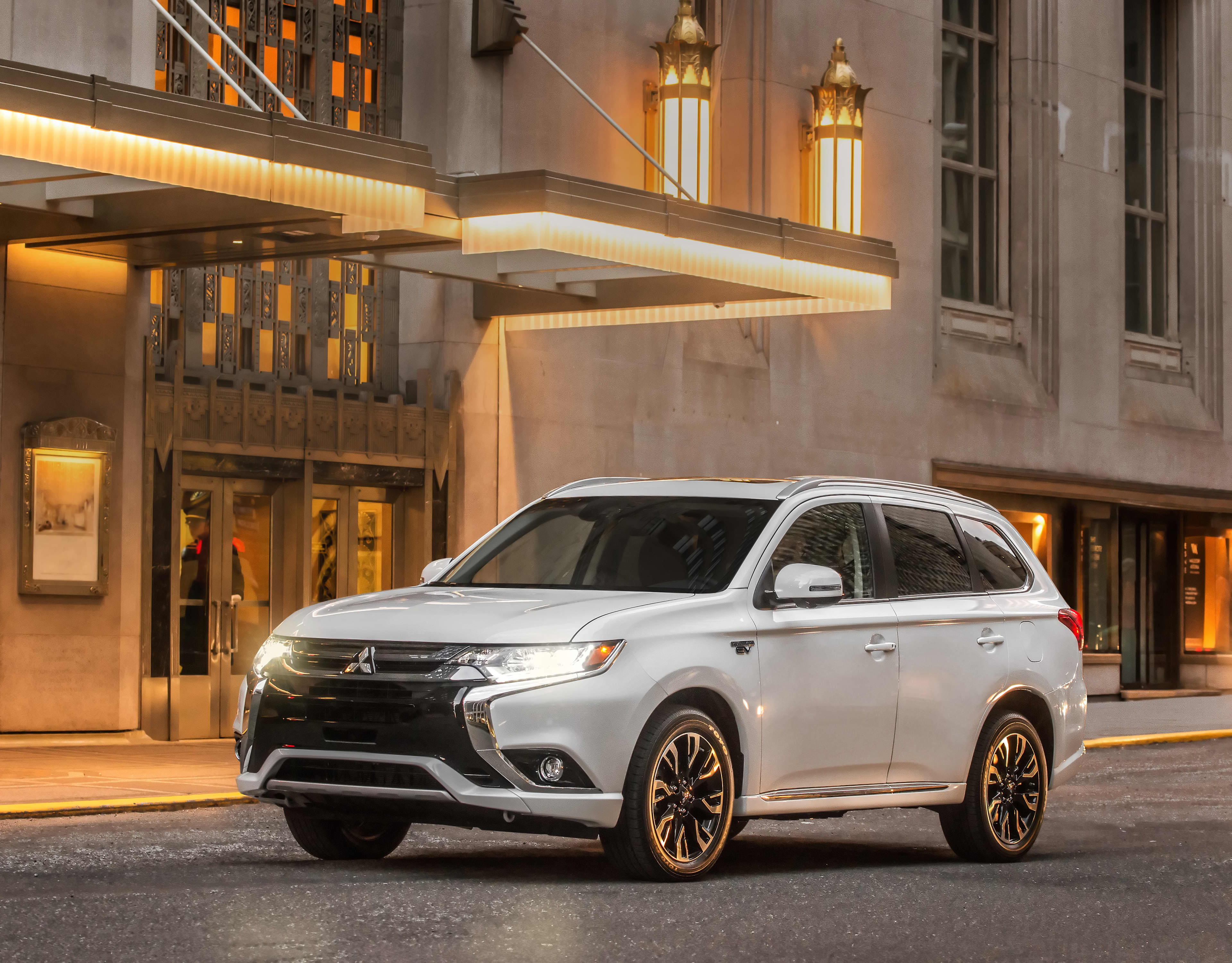 A white Mitsubishi Outlander outside an old city building