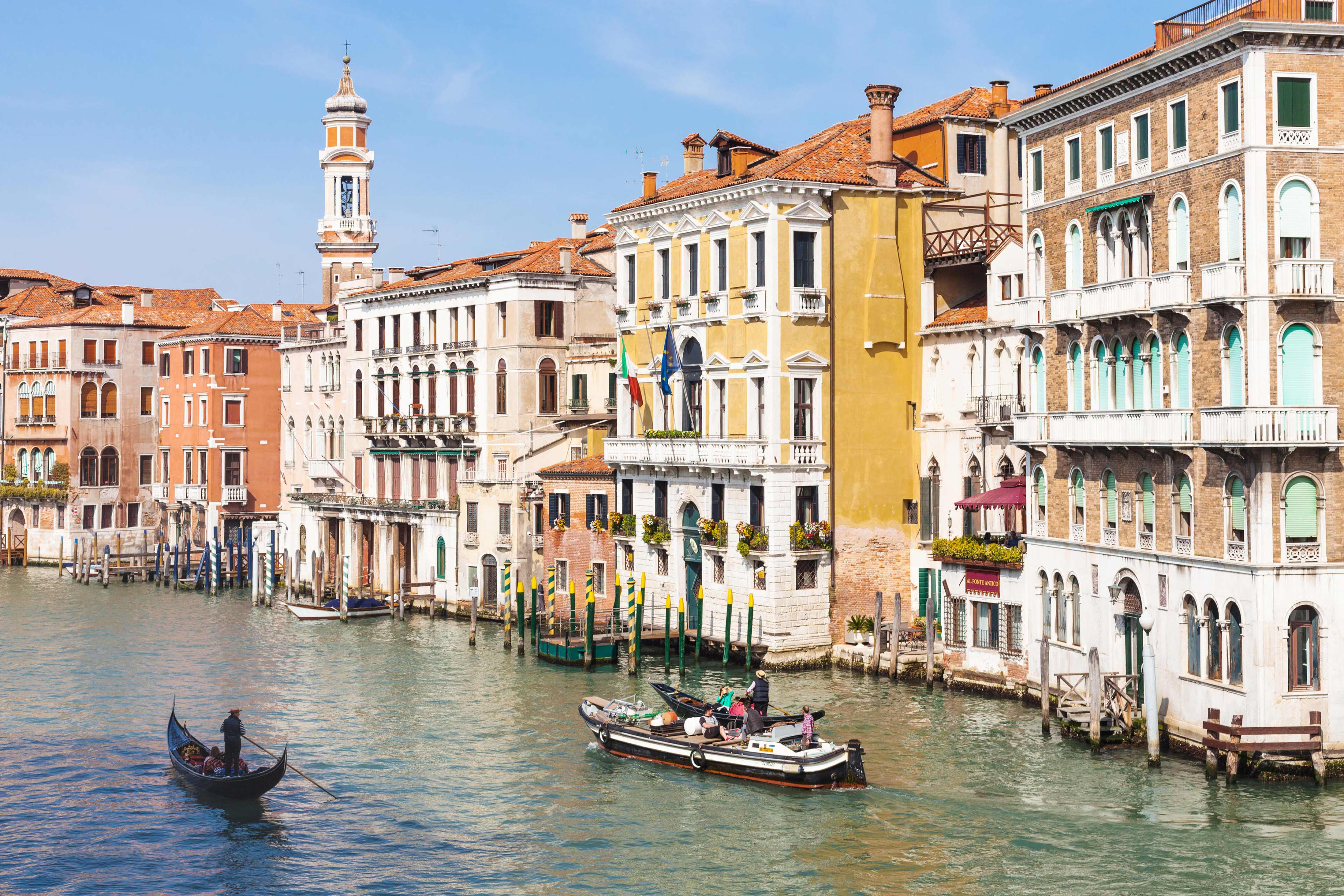 A gondola and a taxi boat on a canal in Venice