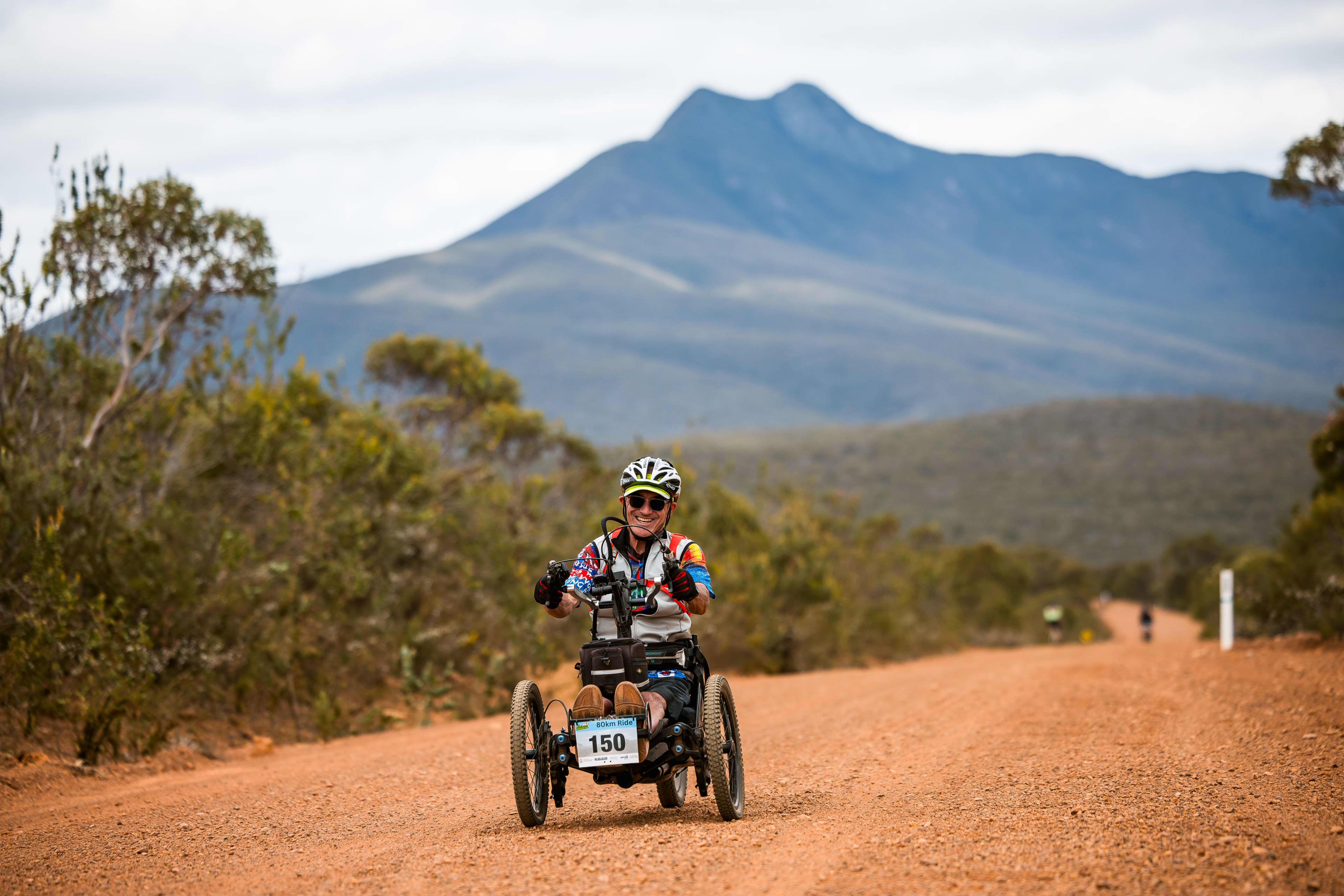 Man on modified three-wheeler on trail with Stirling Ranges in the background