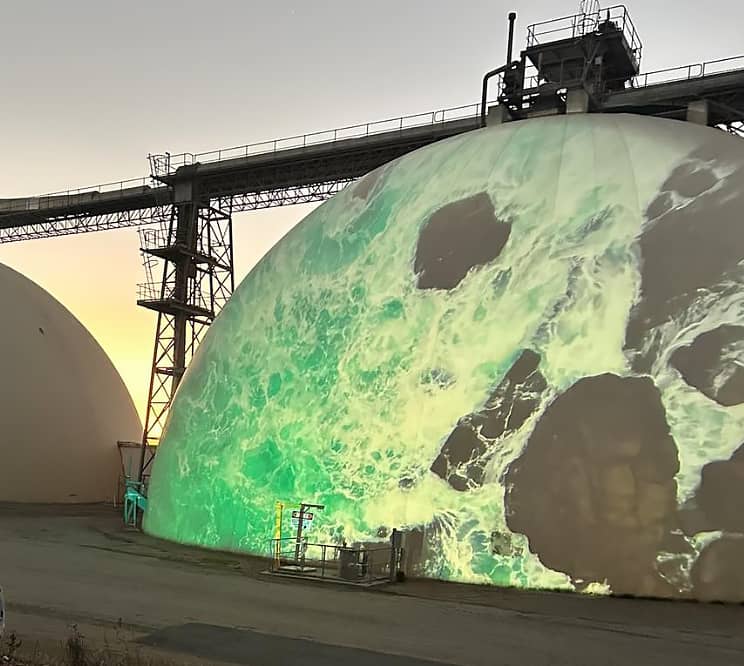 The dome of a grain silo covered with a light projection