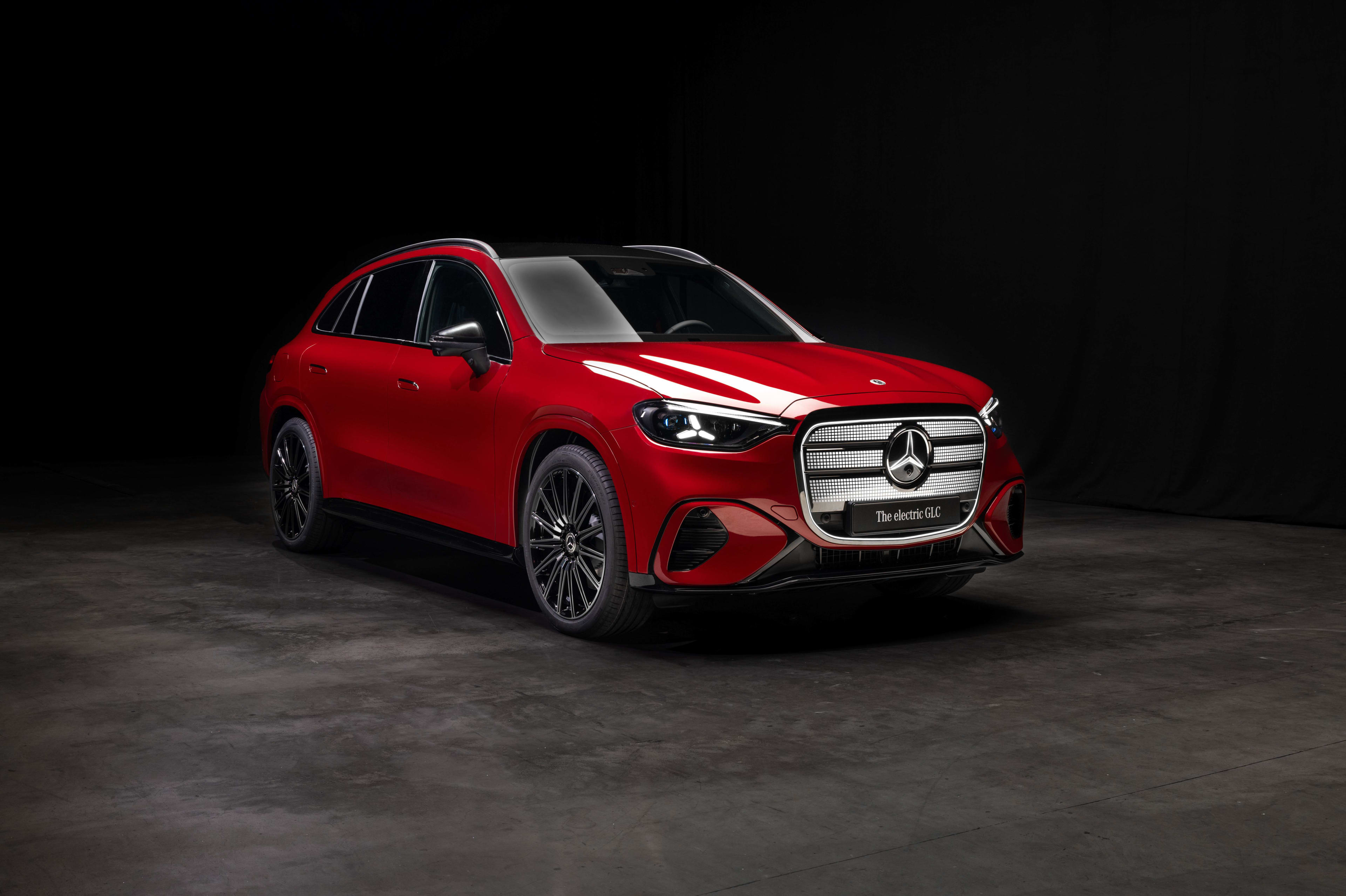 A red Mercedes GLC in a dark studio setting