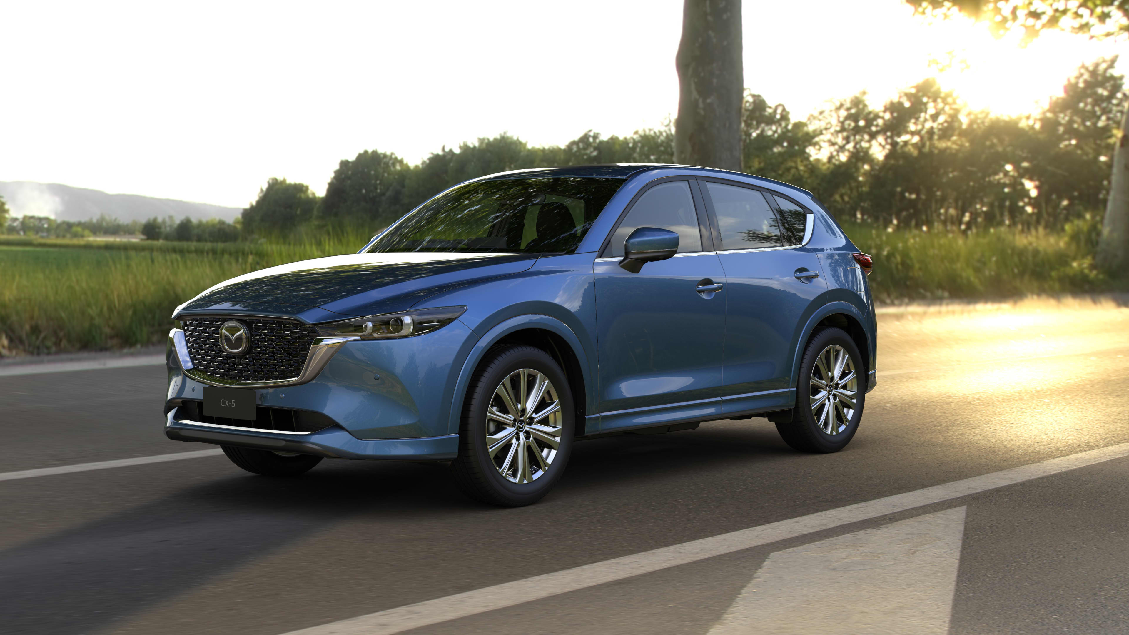 A dark blue Mazda CX5 driving on a country road.