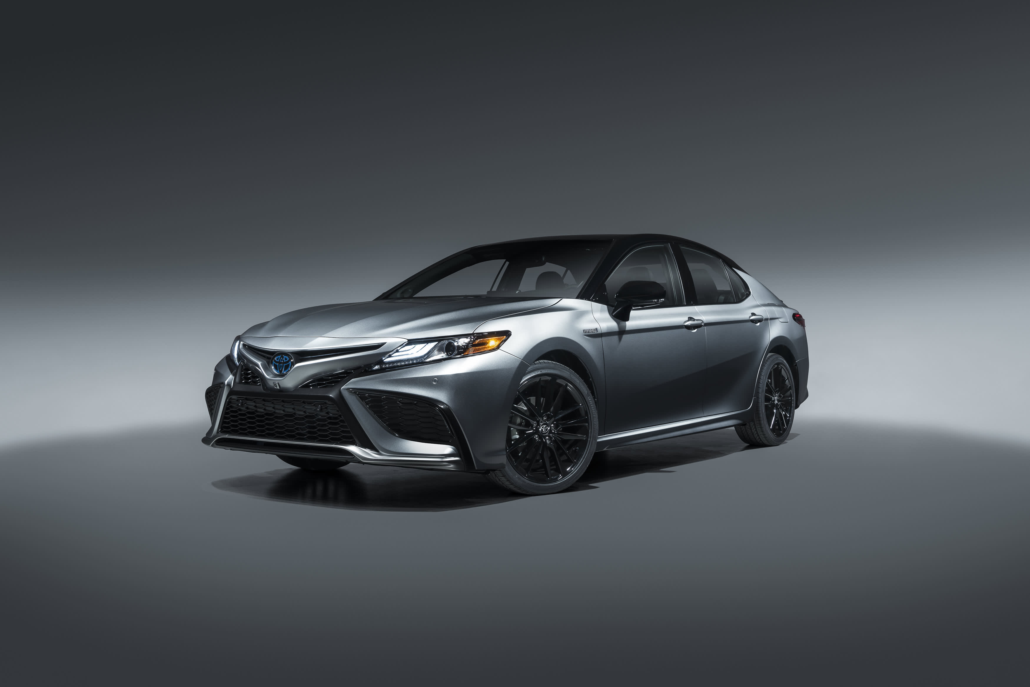 A dark grey Toyota Camry in a studio setting.