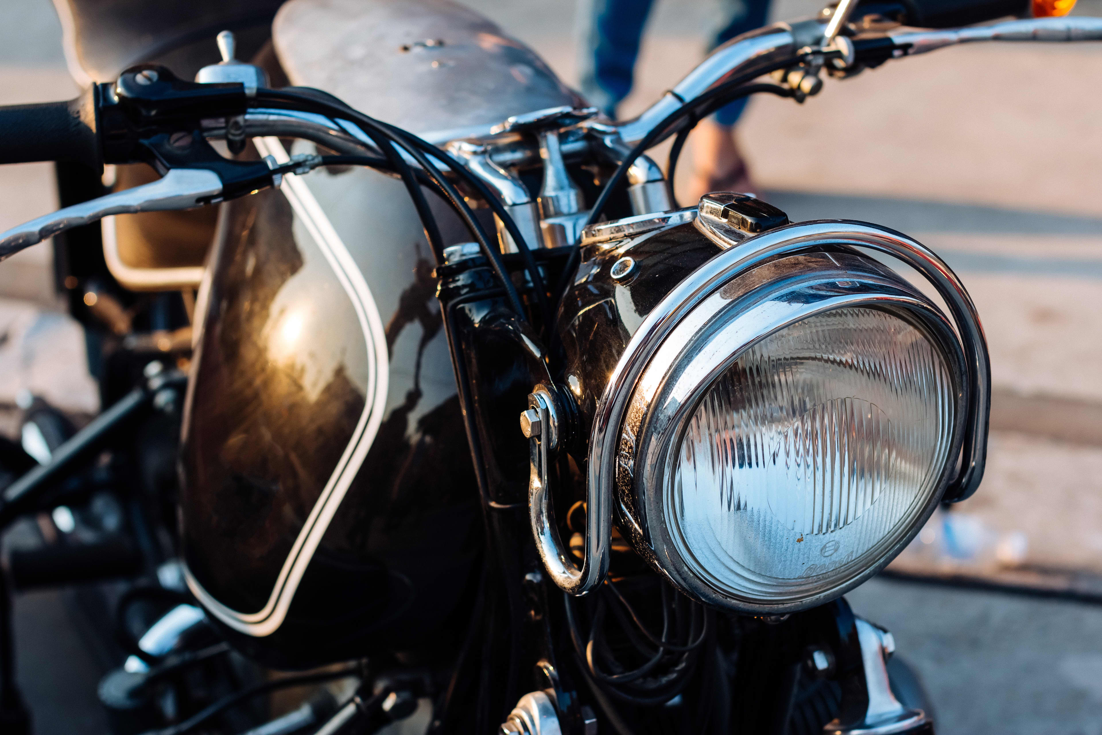 A close-up of a headlight on a classic motorcycle.