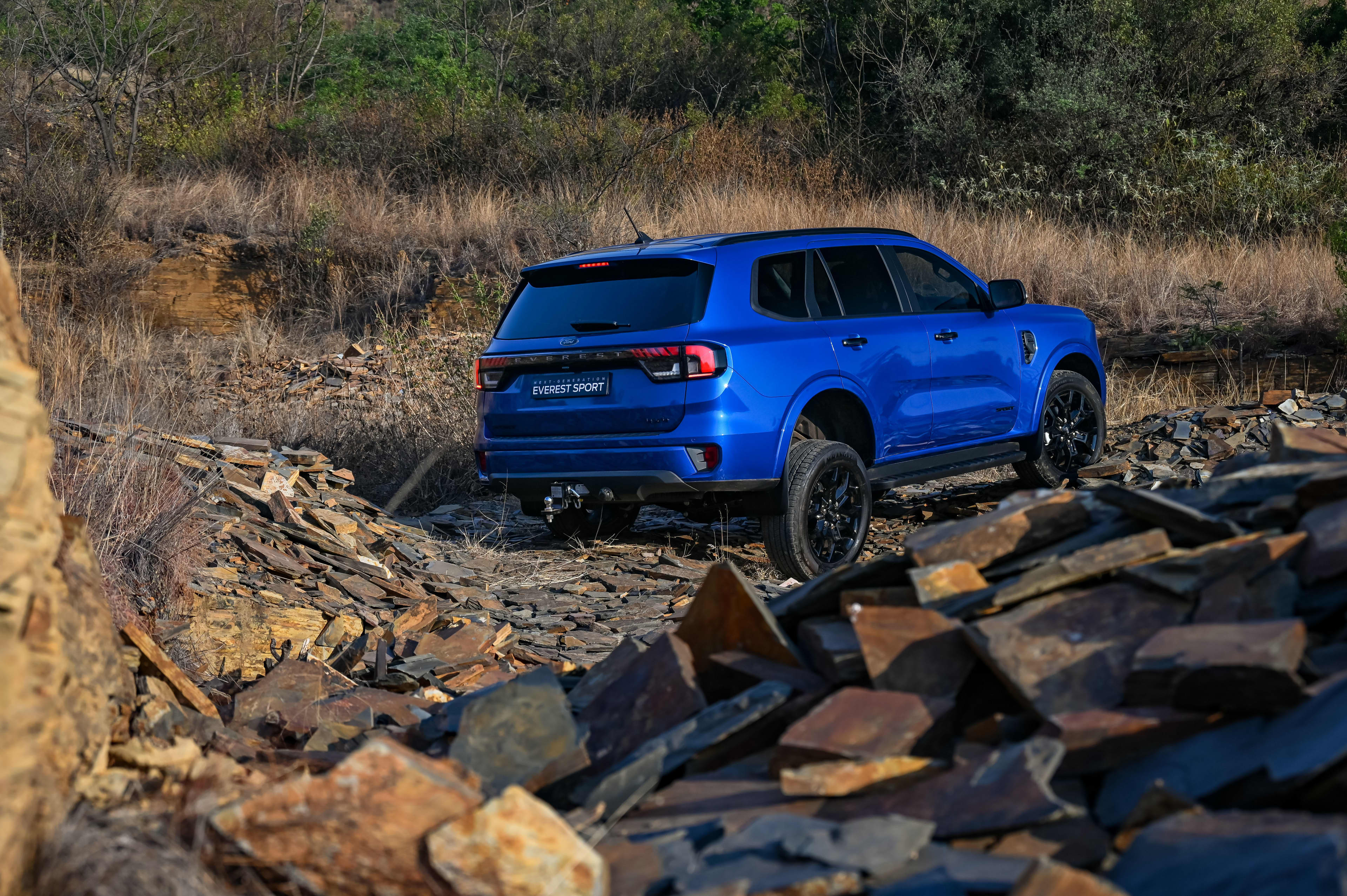 A blue Ford Everest Sport in rocky terrain