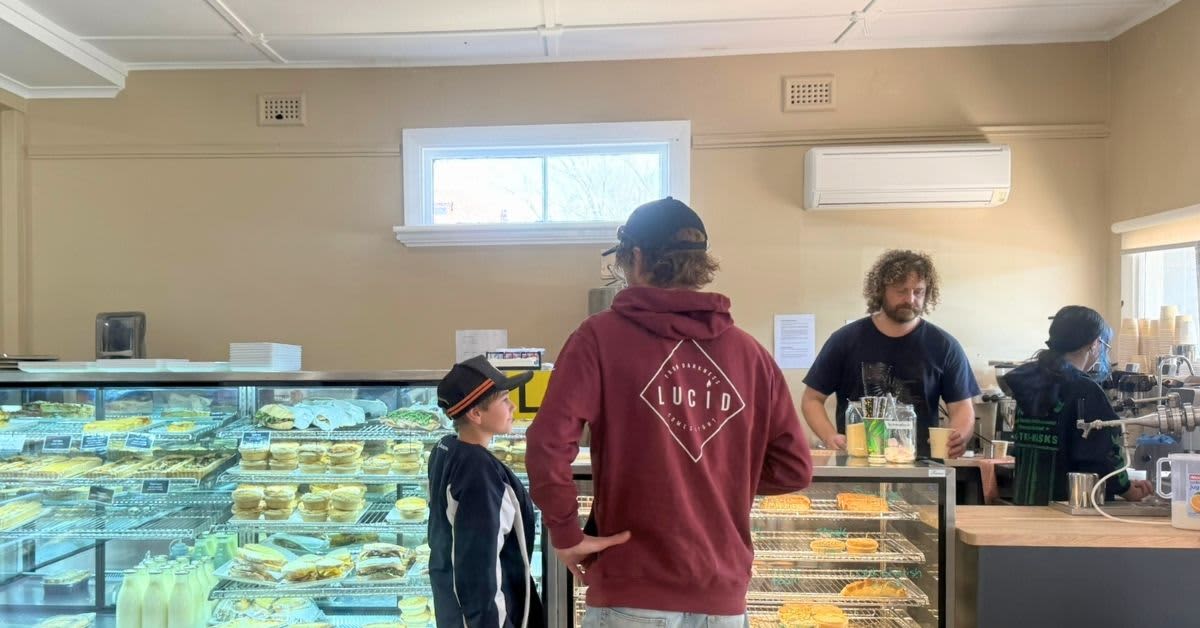 Coffee machine and pie cabinet at bakery and people waiting for coffee