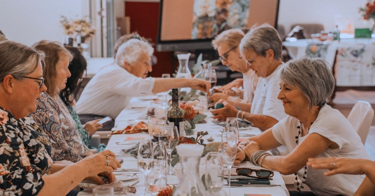 Group of people sitting around long table chatting