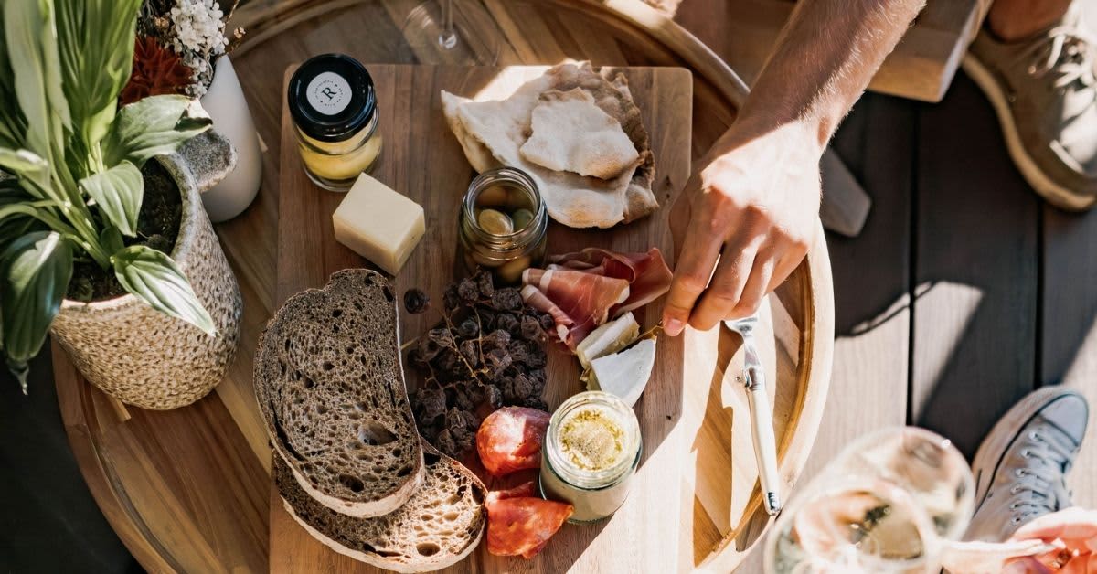 Grazing board with bread, deli meats, olives and cheese