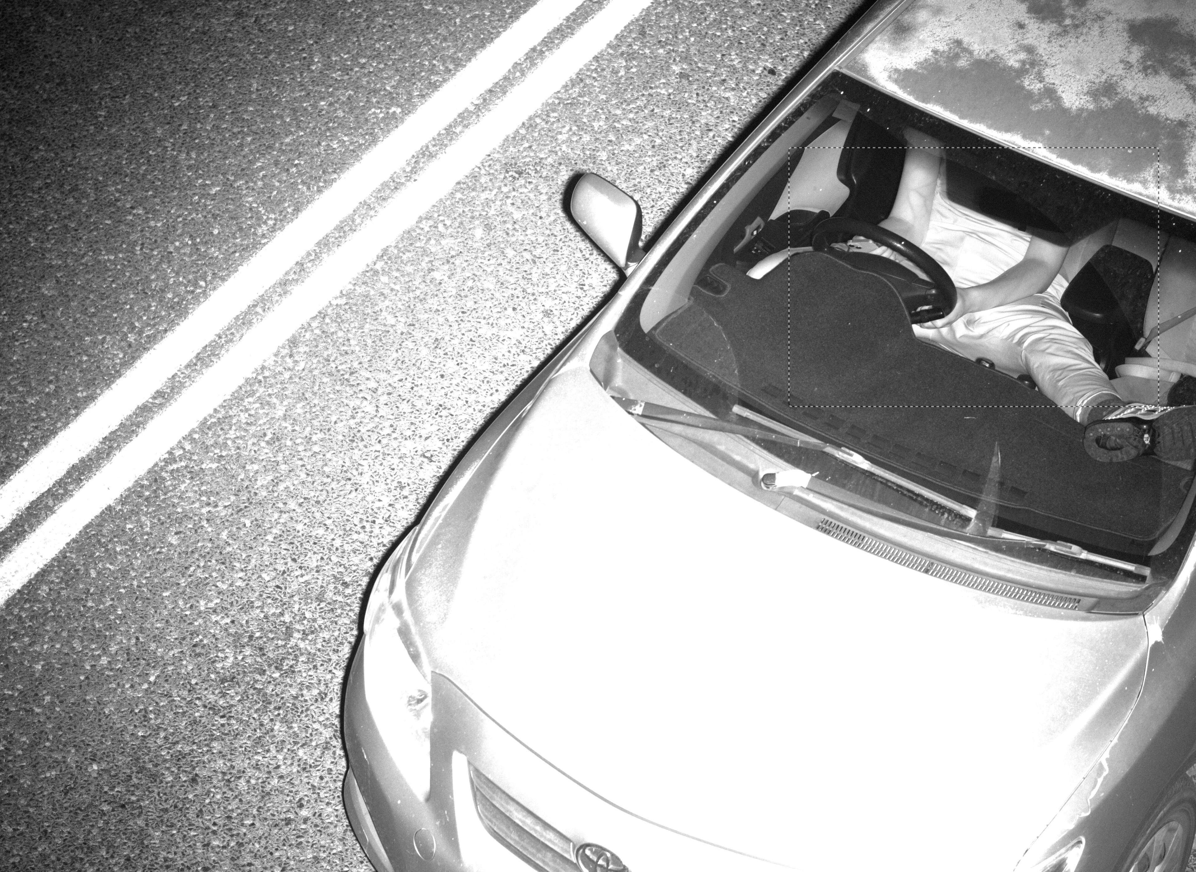 A road safety camera image of a driver not wearing a seatbelt