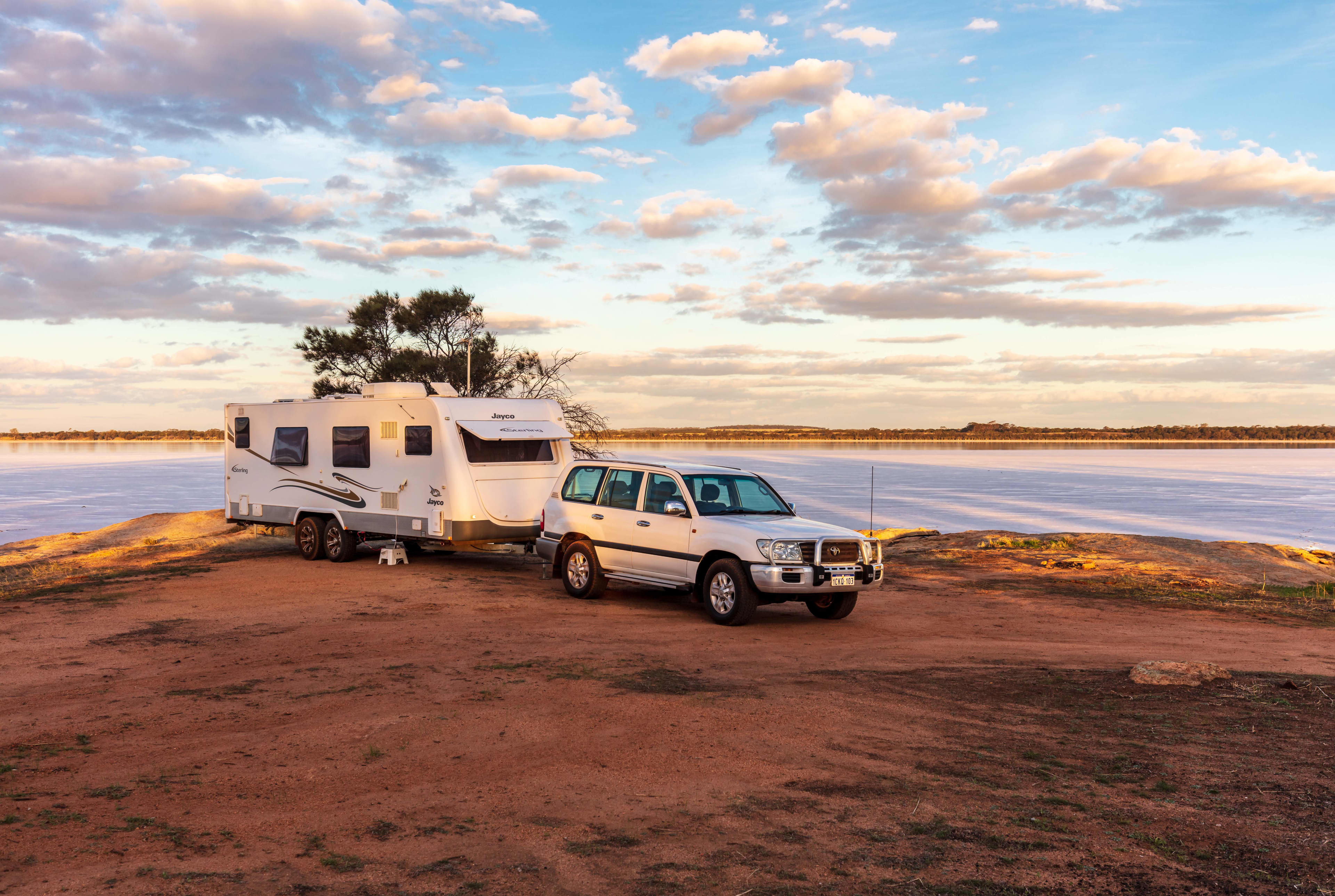 A caravan parked in a clearing near the beach