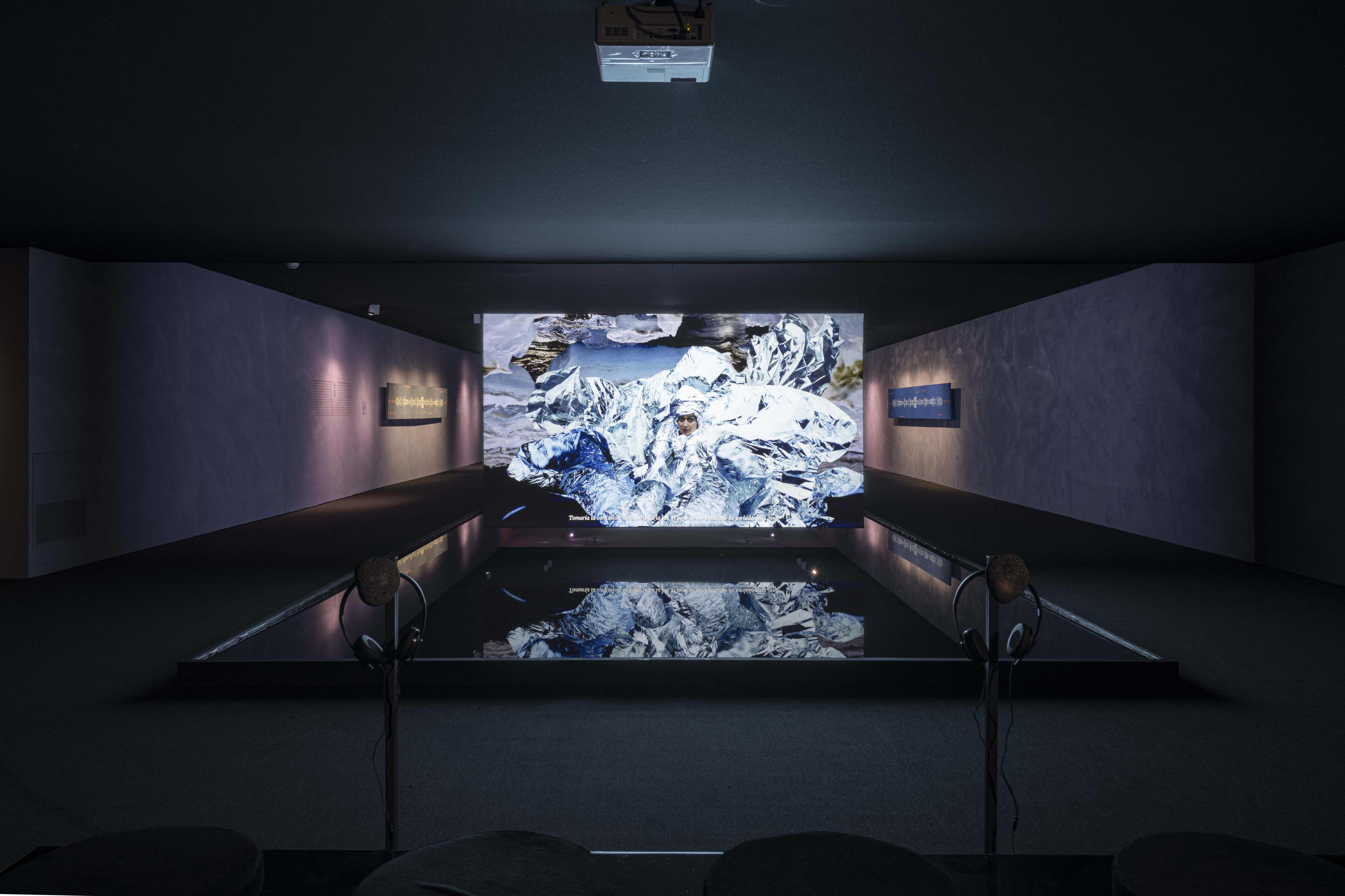 A dark room with a wall projection
