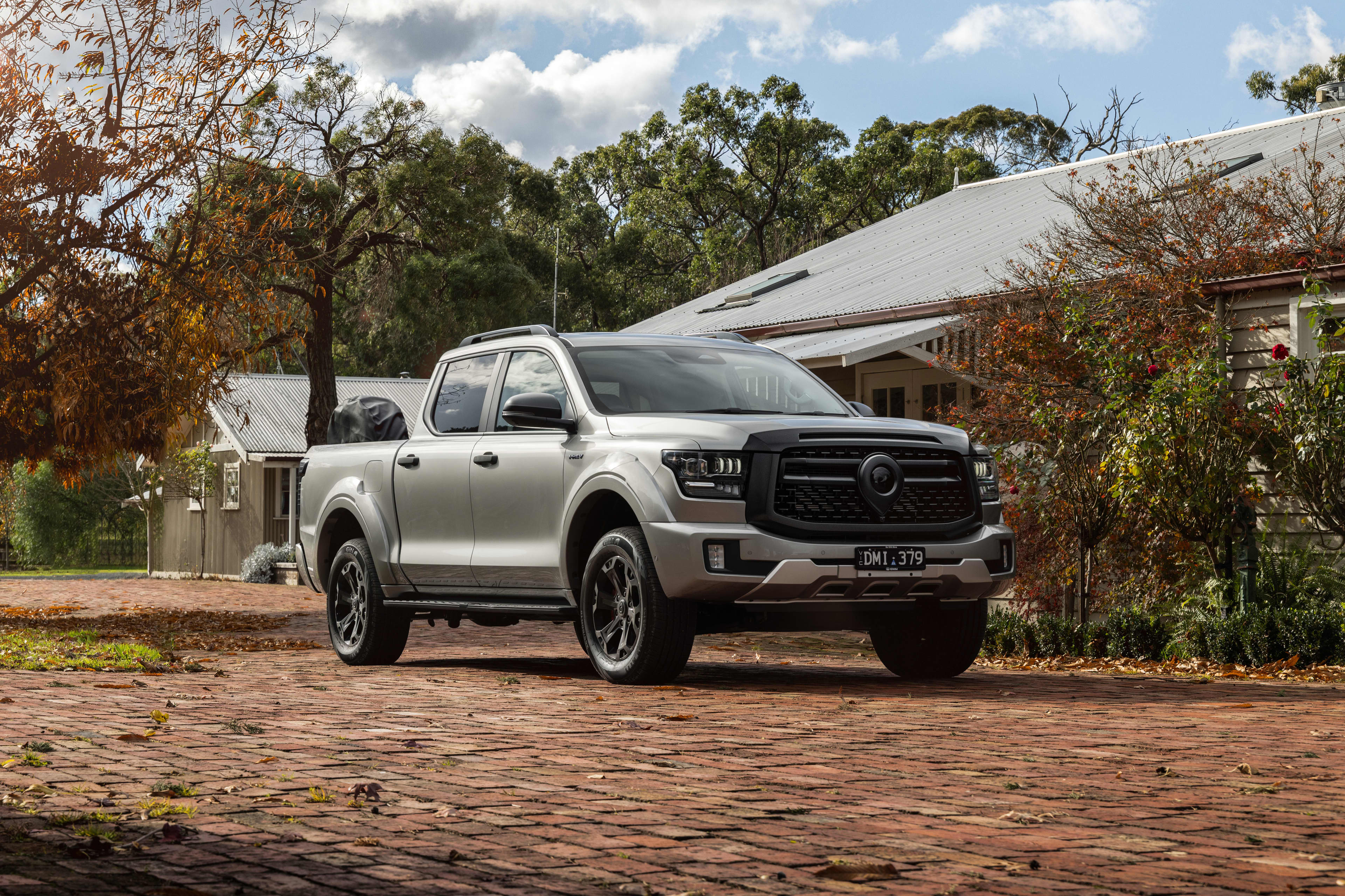 2025 GWM Cannon Alpha PHEV parked on a driveway outside a home with trees around