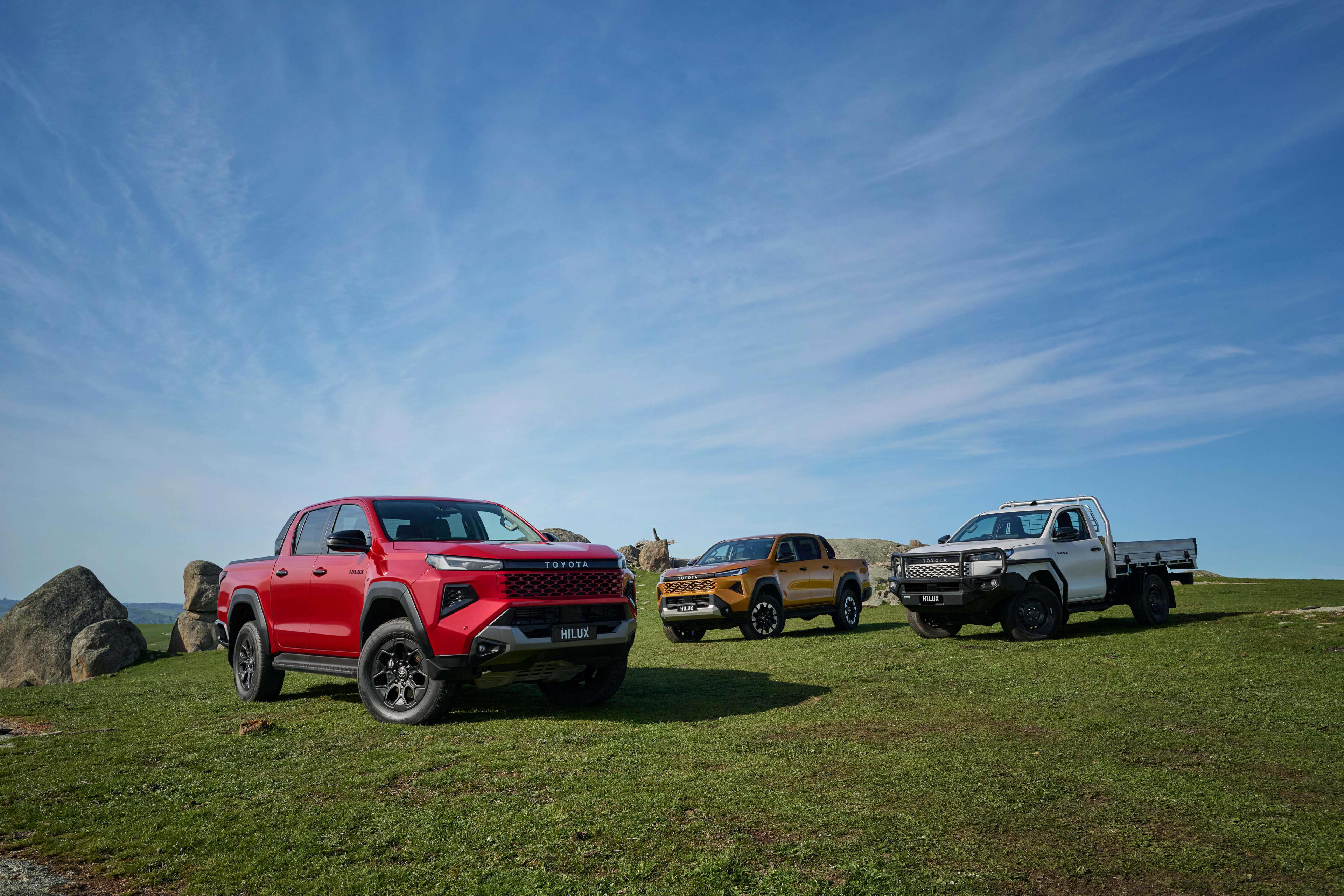Three new Toyota HiLux's parked in a green field