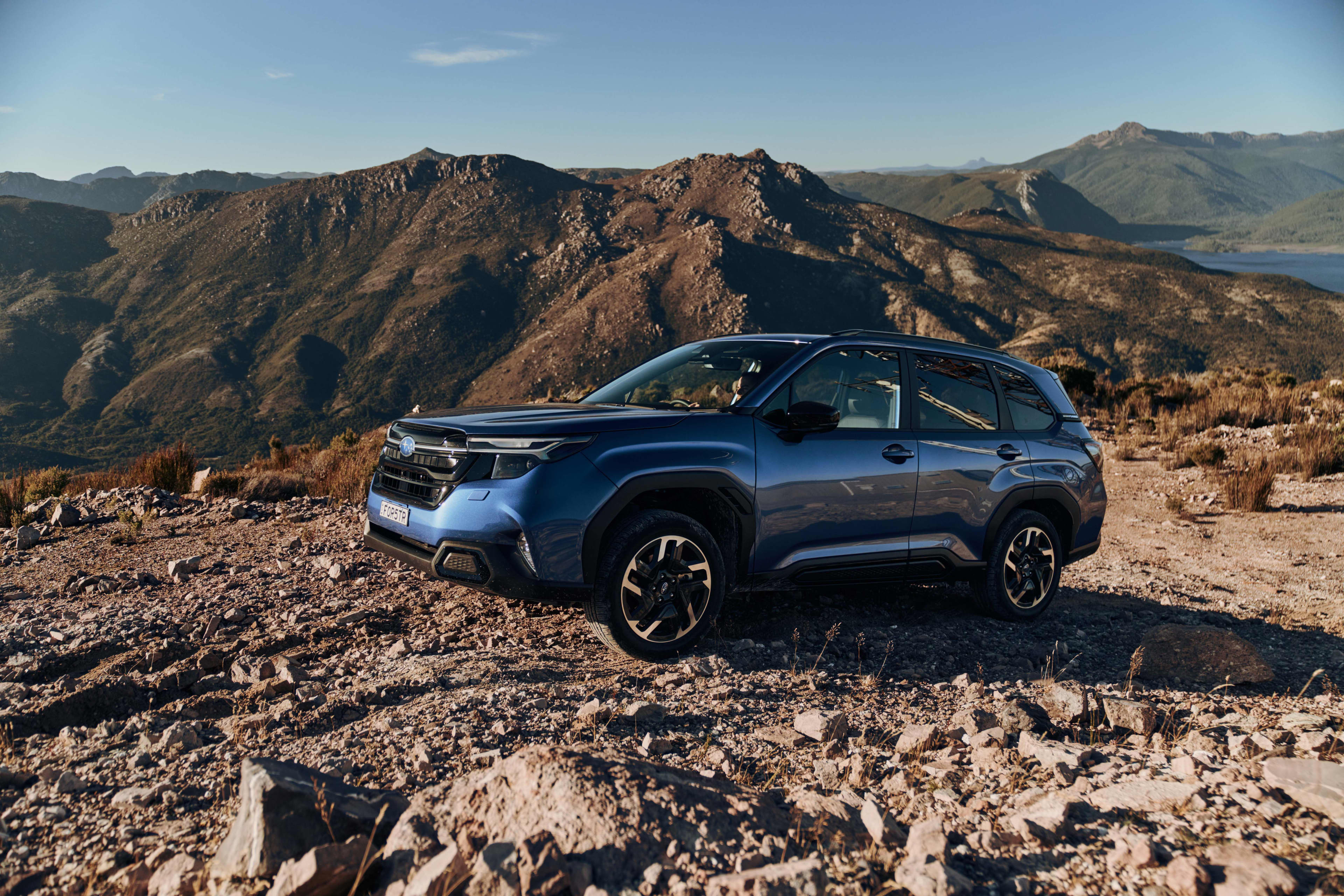 A blue Subaru Forester in a rocky landscape