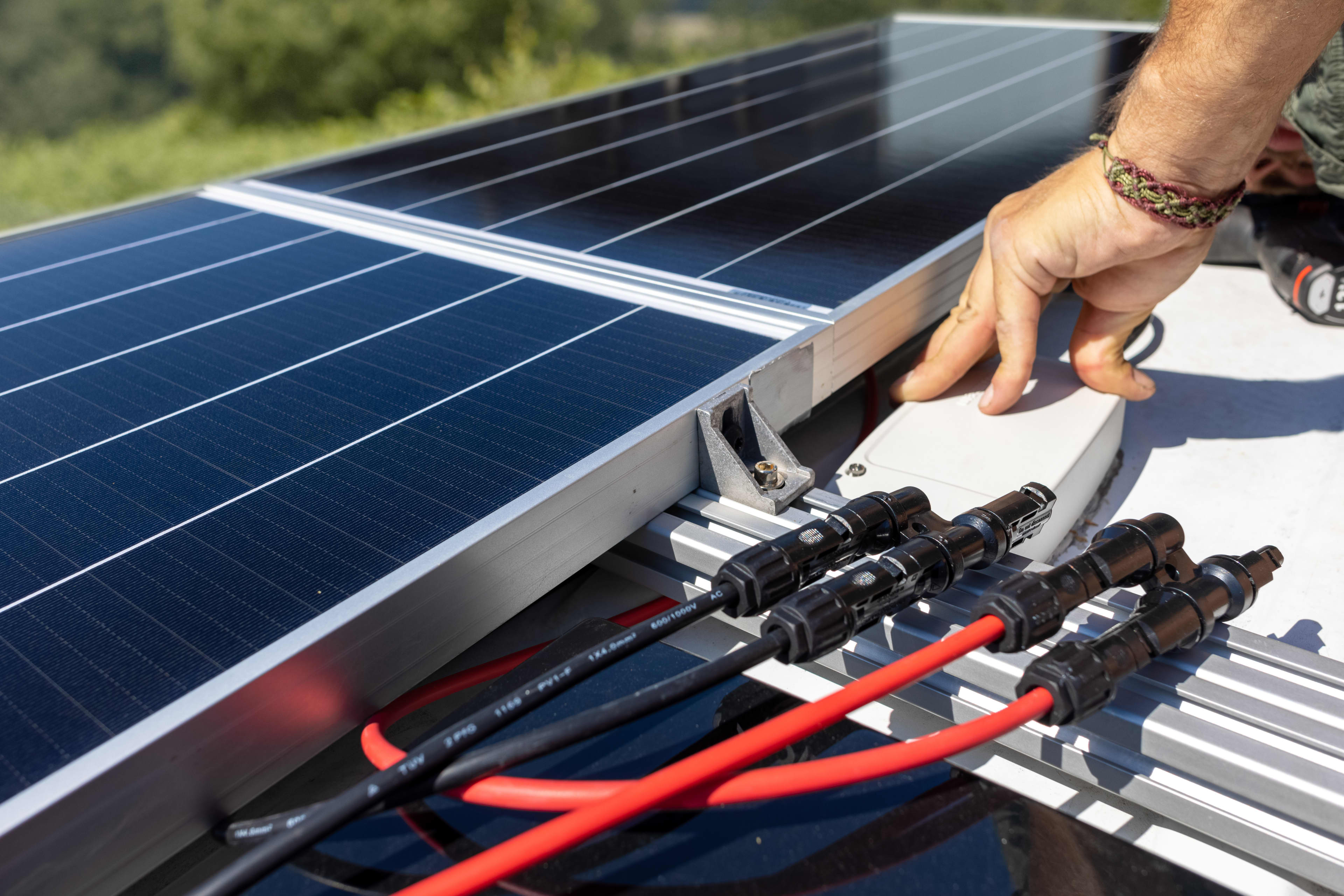 A close-up of some electrical wires and solar panels on a caravan roof.