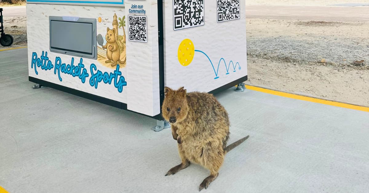 A quokka sits in front of pickleball self-serve kiosk